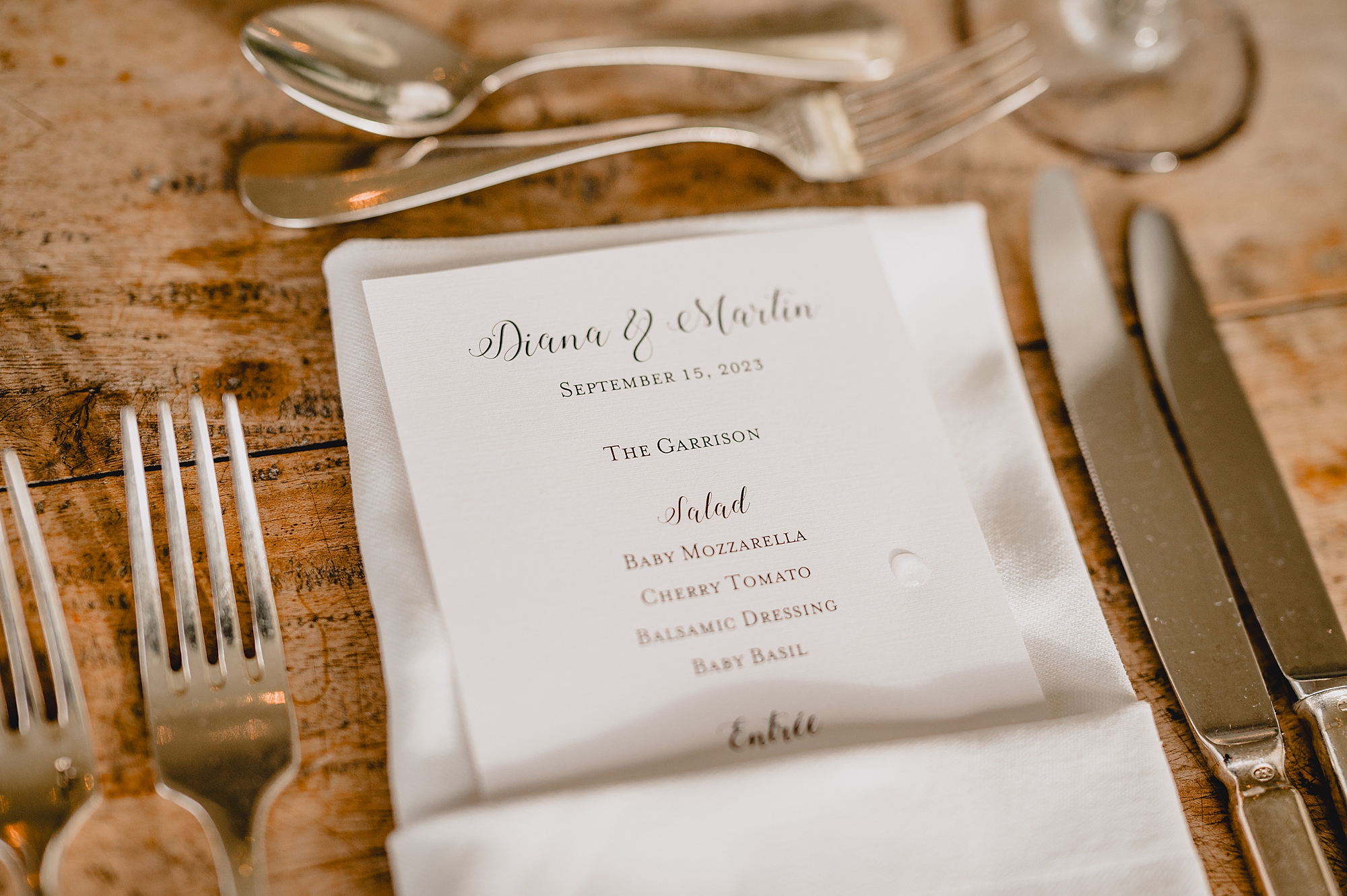 ivory menu sits in napkin on wooden table at the Garrison in Hudson NY