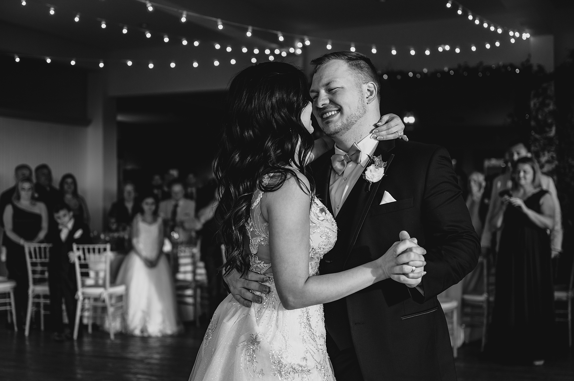 groom hugs bride to him during first dance at wedding reception at the Garrison