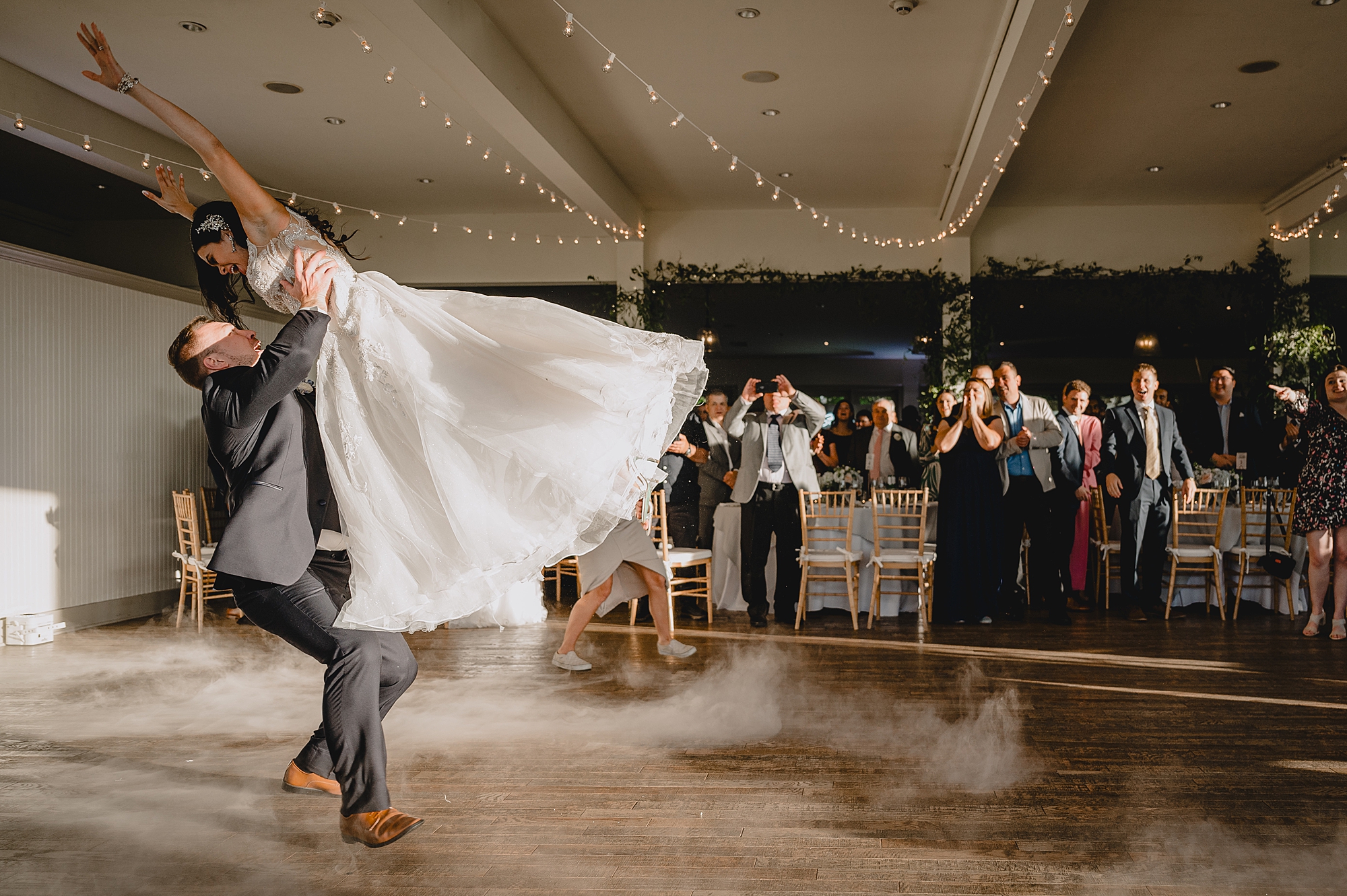 groom lifts up bride during first dance at wedding reception at the Garrison