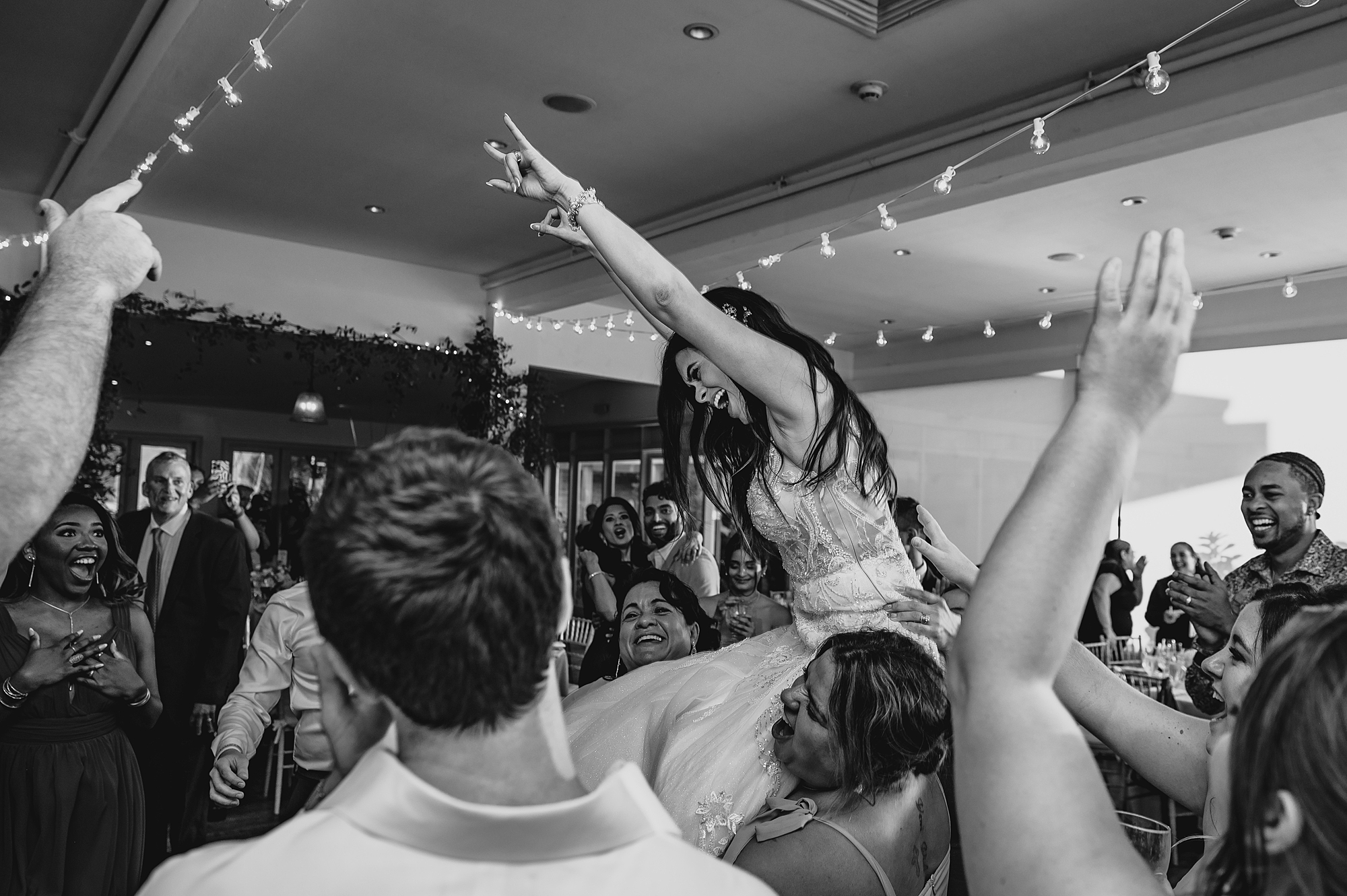 guests lift up bride during wedding reception at the Garrison