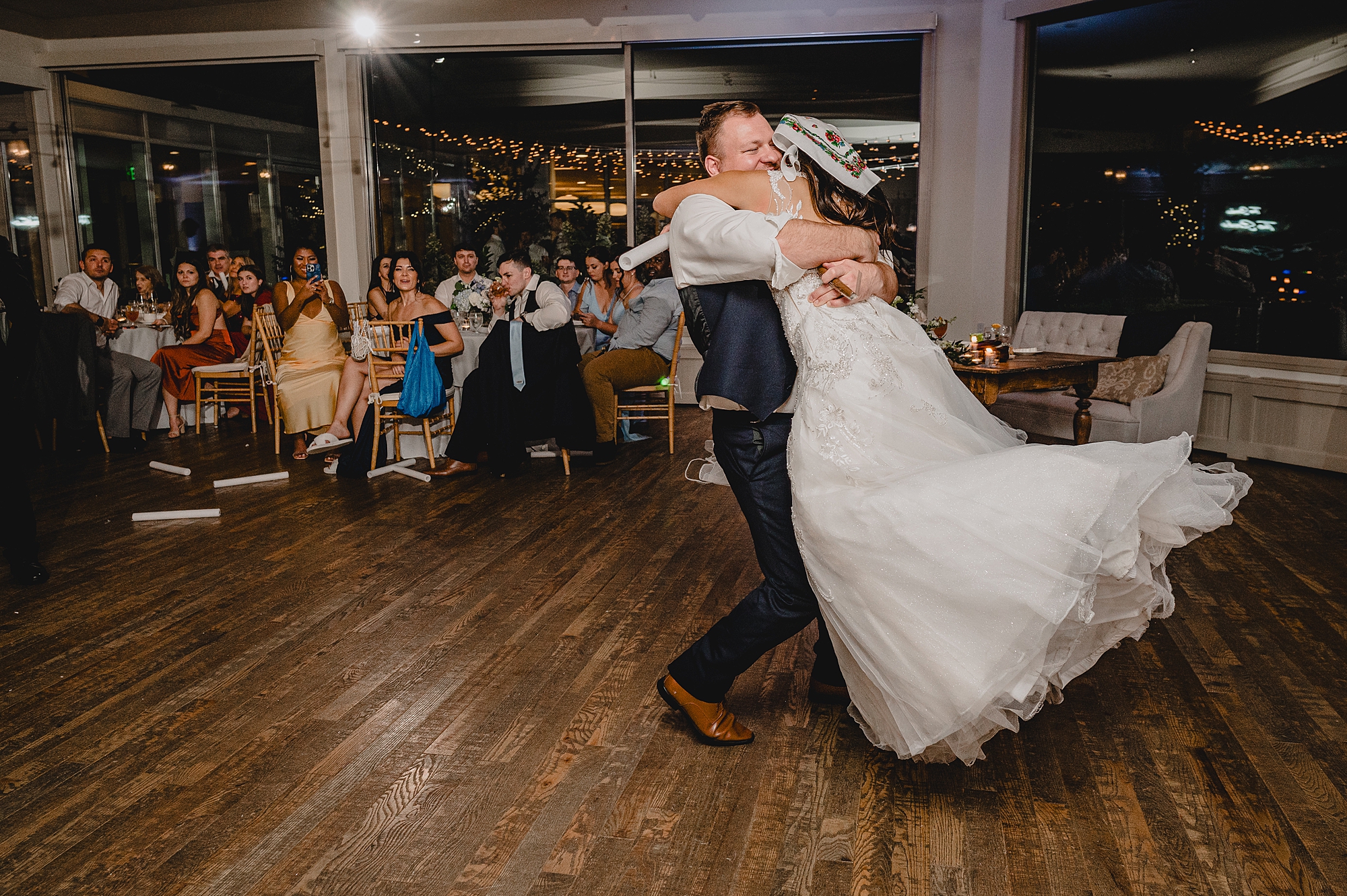 groom twirls bride around on dance floor at reception