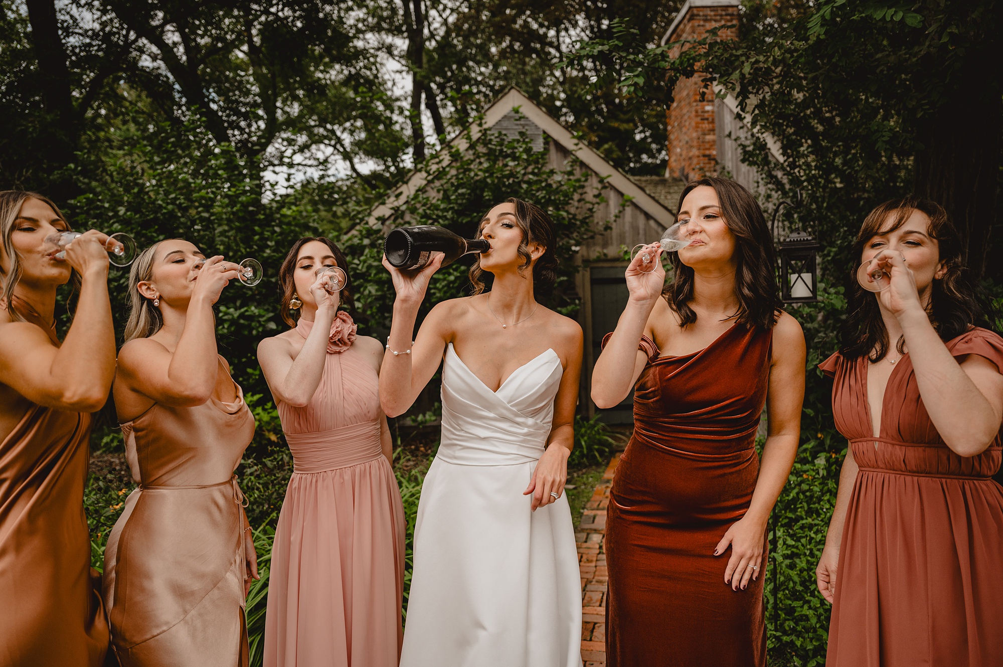 bride drinks champagne while bridesmaids blow bubbles 