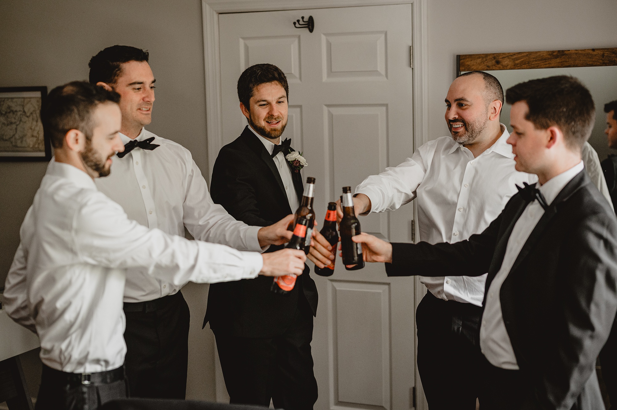 groom and groomsmen toast drinks inside suite at Waterloo Village