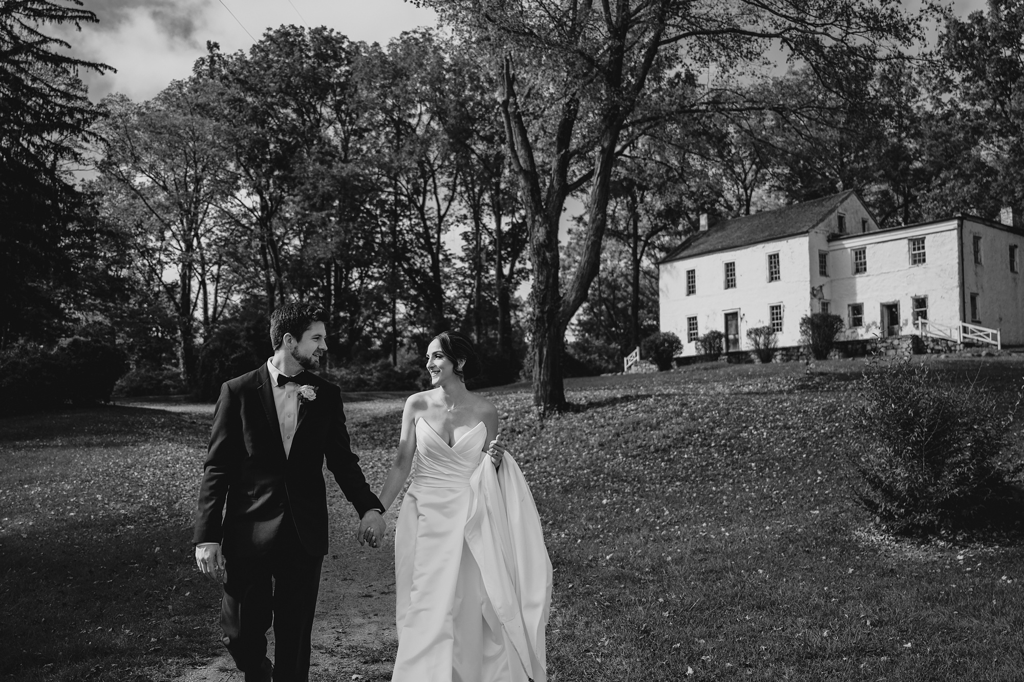 bride and groom walk down dirt path at Waterloo Village