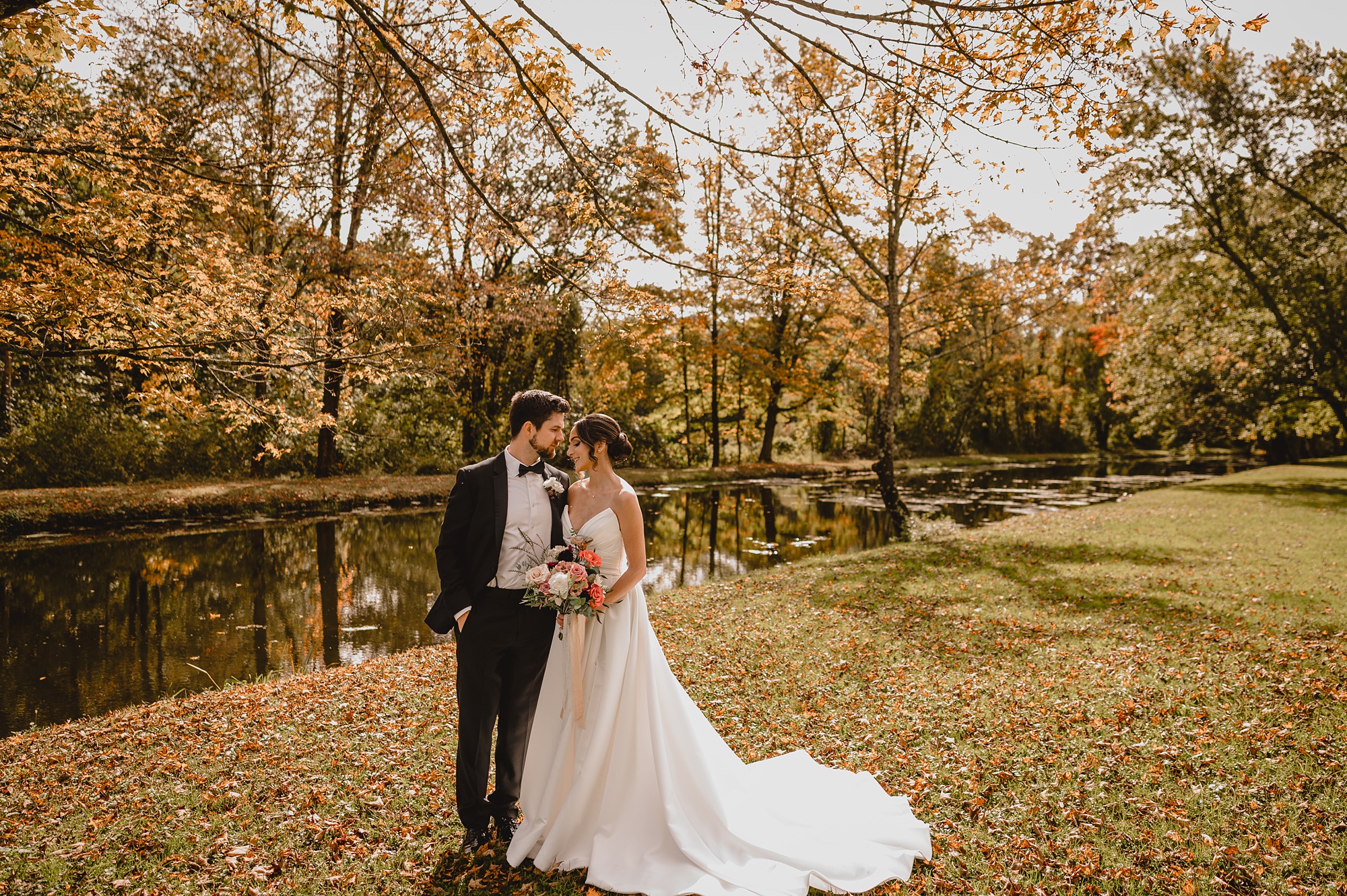 bride and groom hug by pond at Waterloo Village