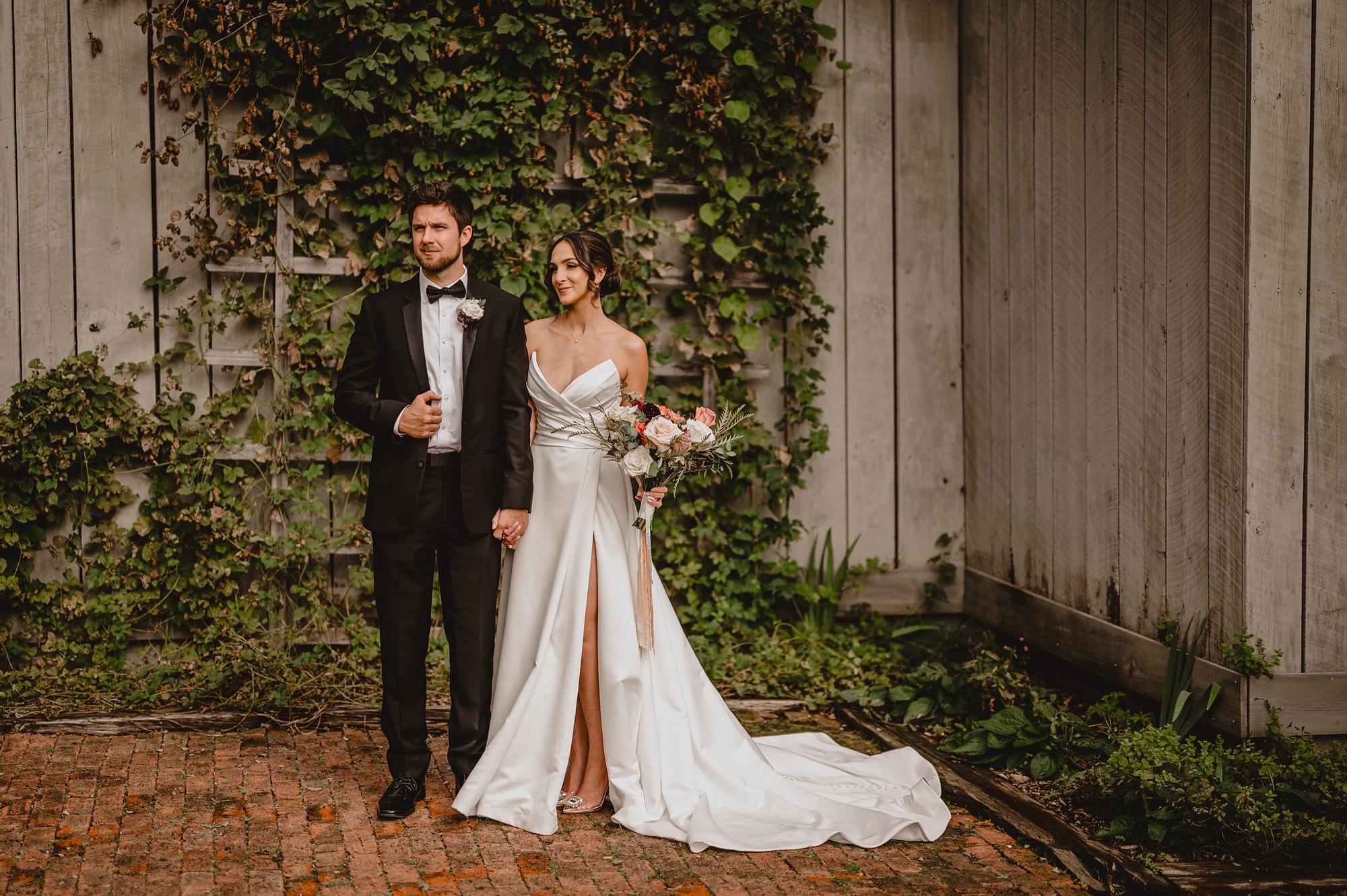 bride and groom stand by ivy covered wall at Waterloo Village