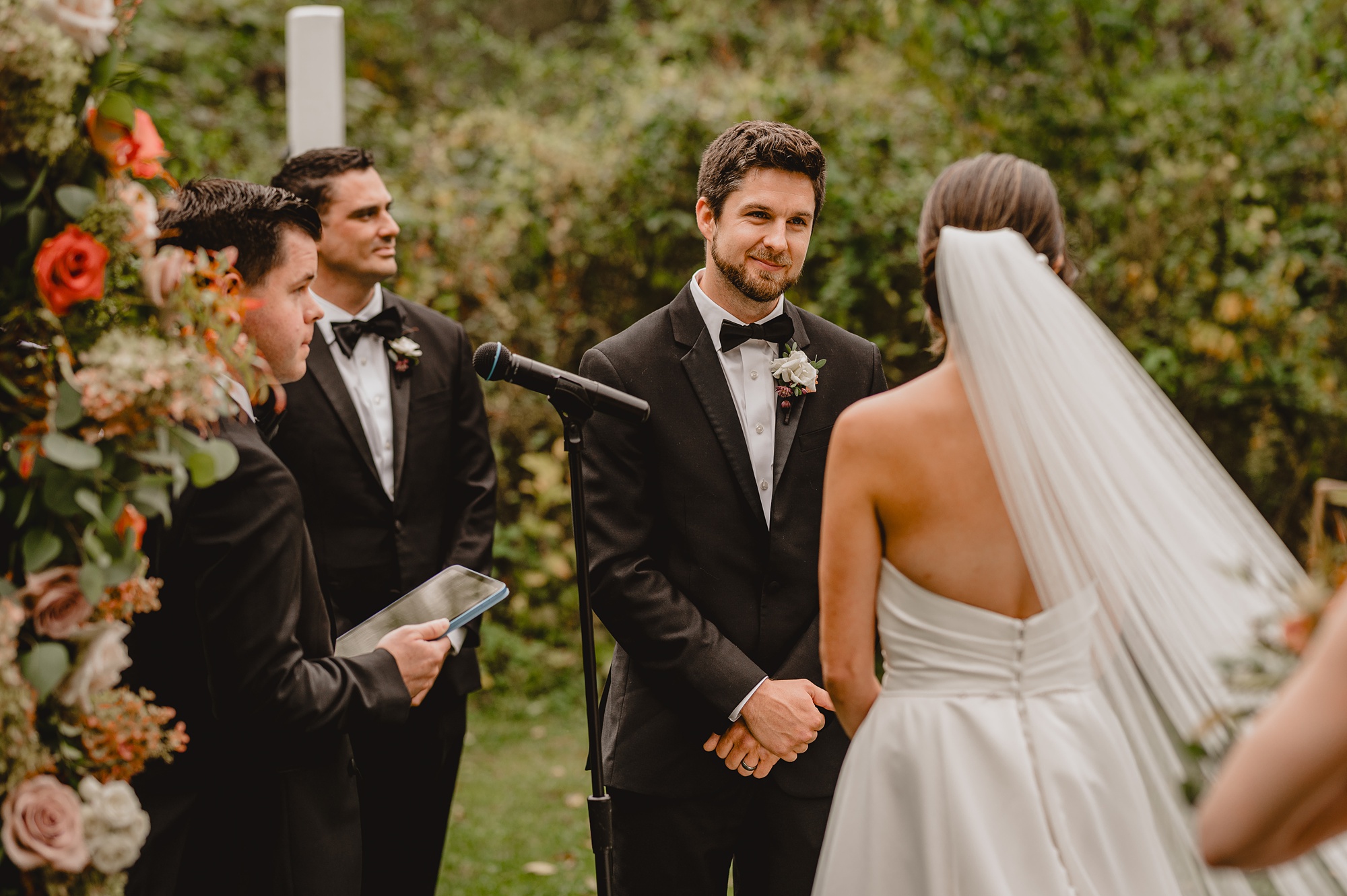 groom smirks at bride during vows at Waterloo Village
