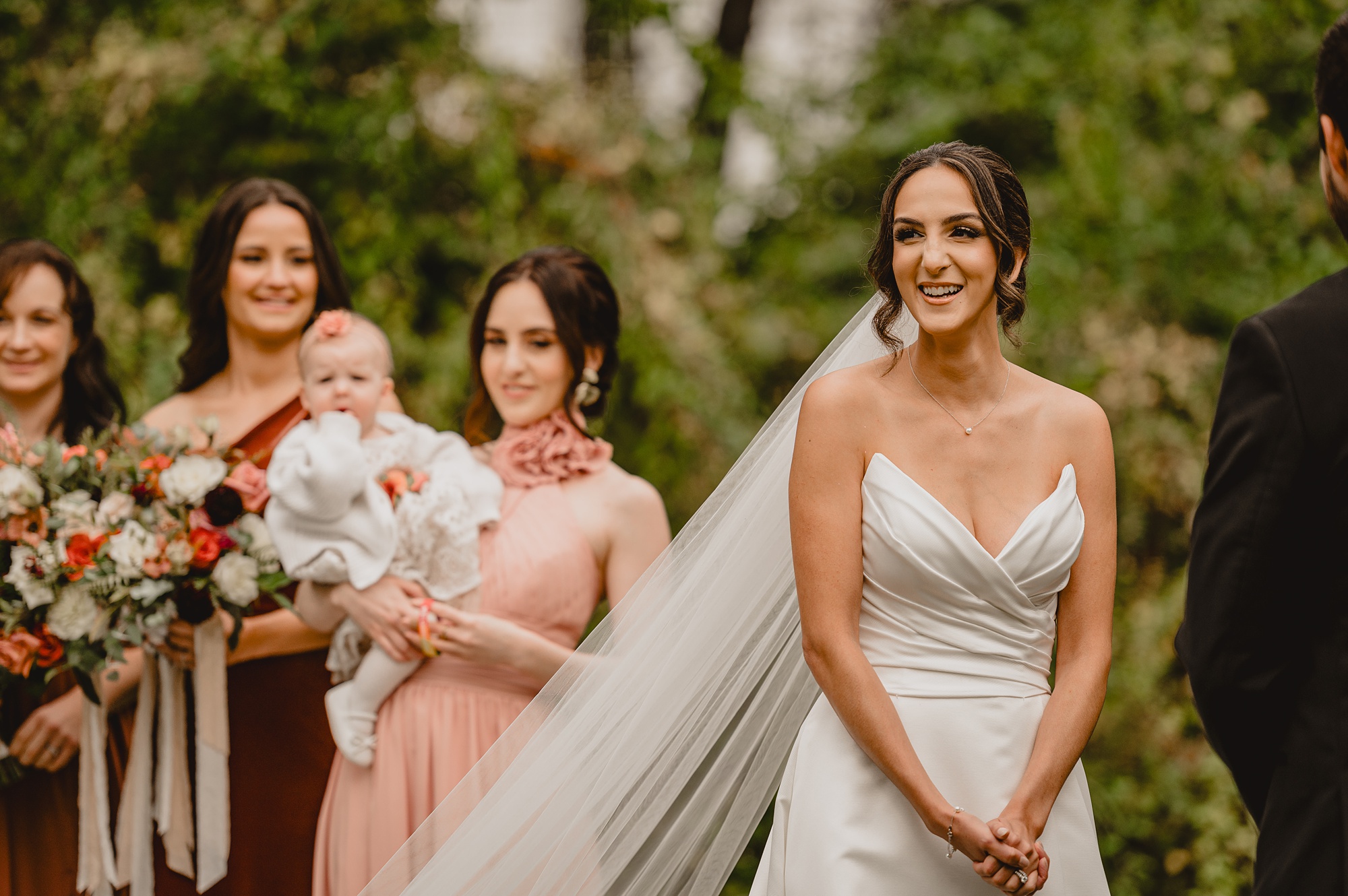 bride smiles out at guests during wedding ceremony at Waterloo Village
