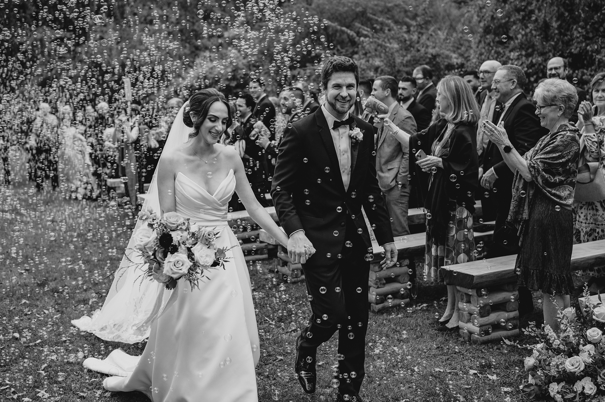 bride and groom hold hands walking up aisle after ceremony at Waterloo Village