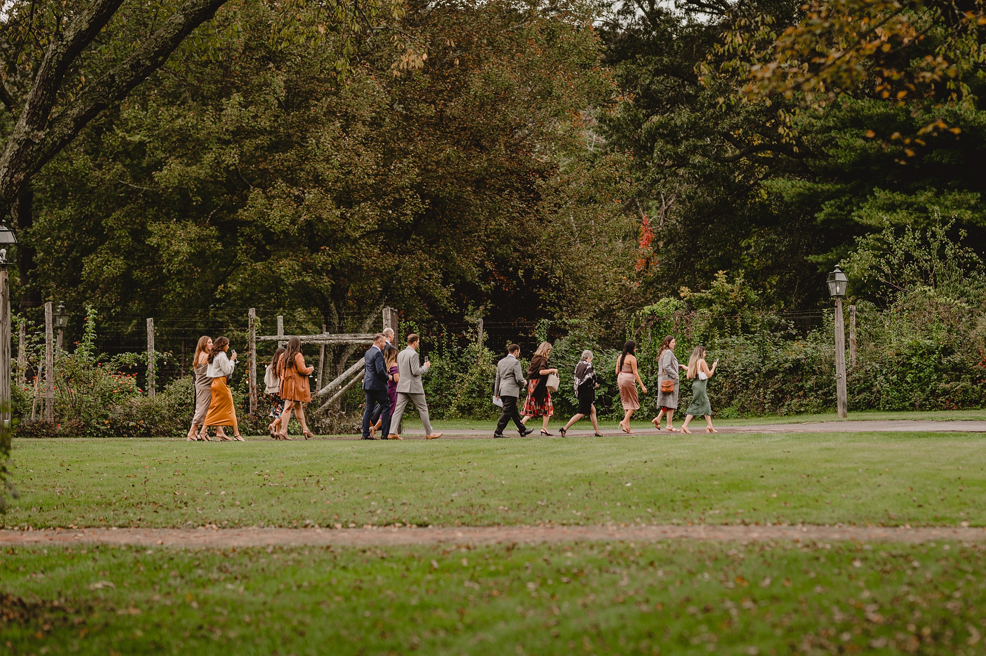 wedding guests walk across lawn at Waterloo Village