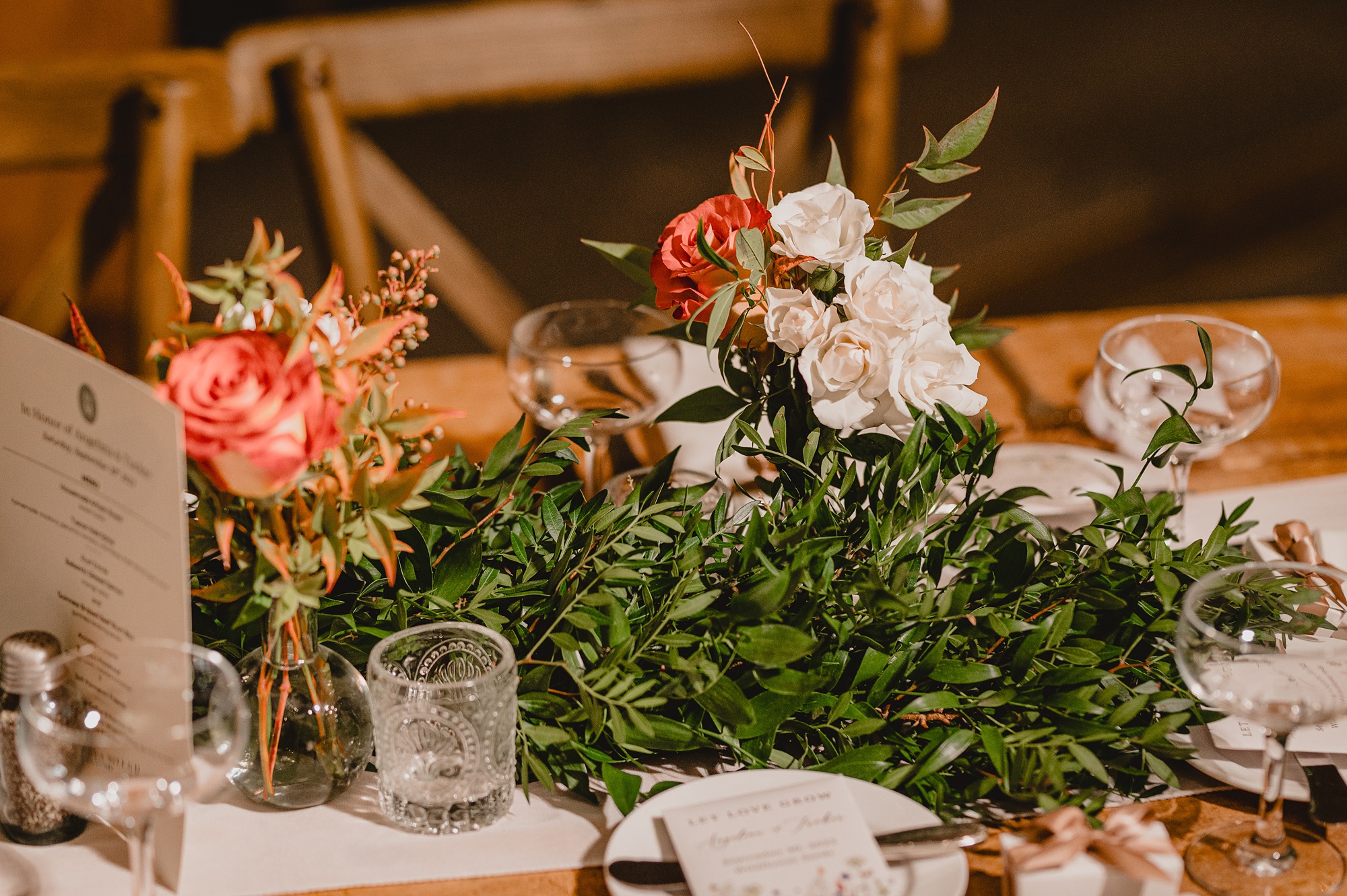 pink and white flowers sit on center of wooden table 