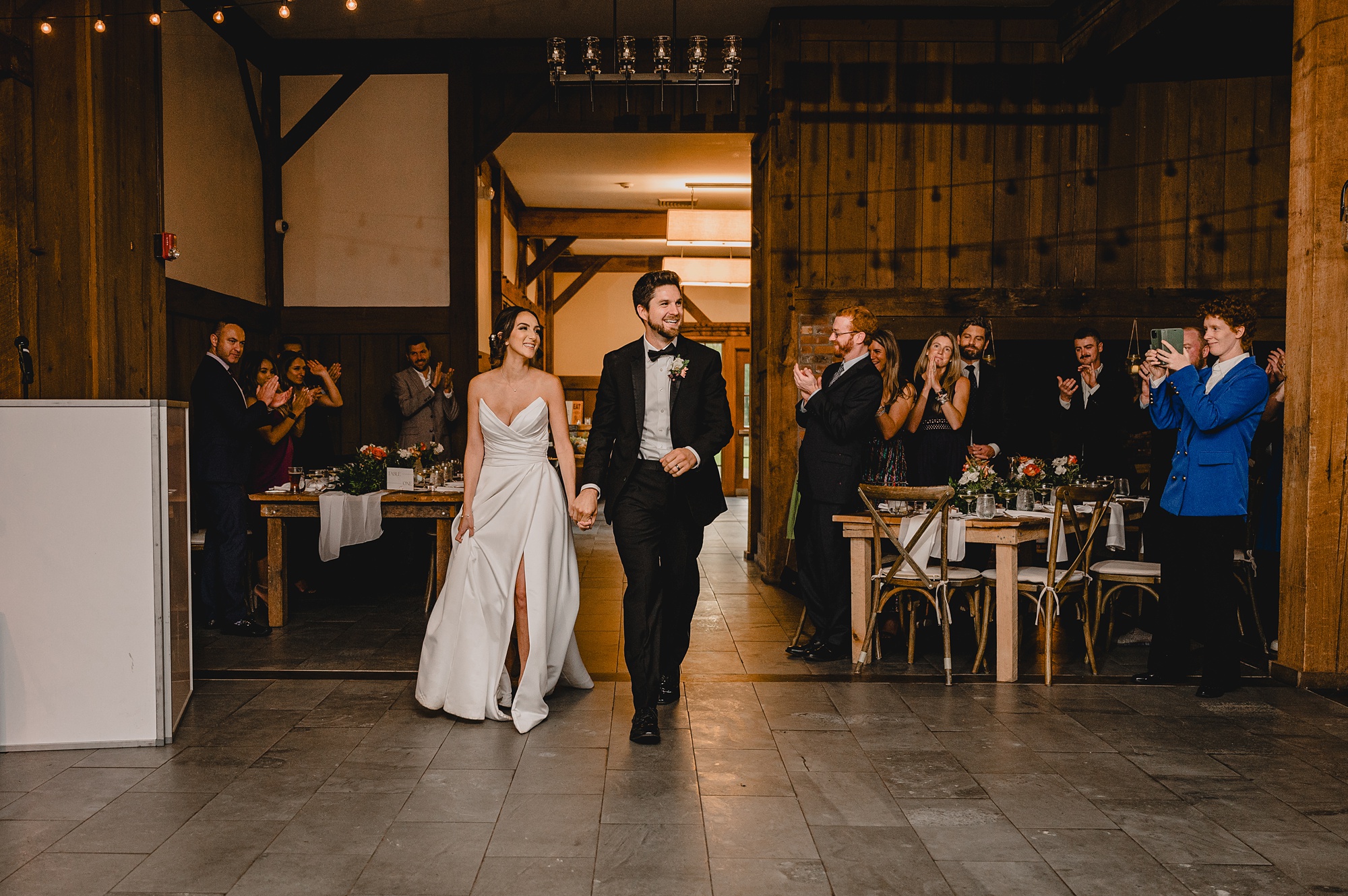 bride and groom enter wedding reception in barn at Waterloo Village