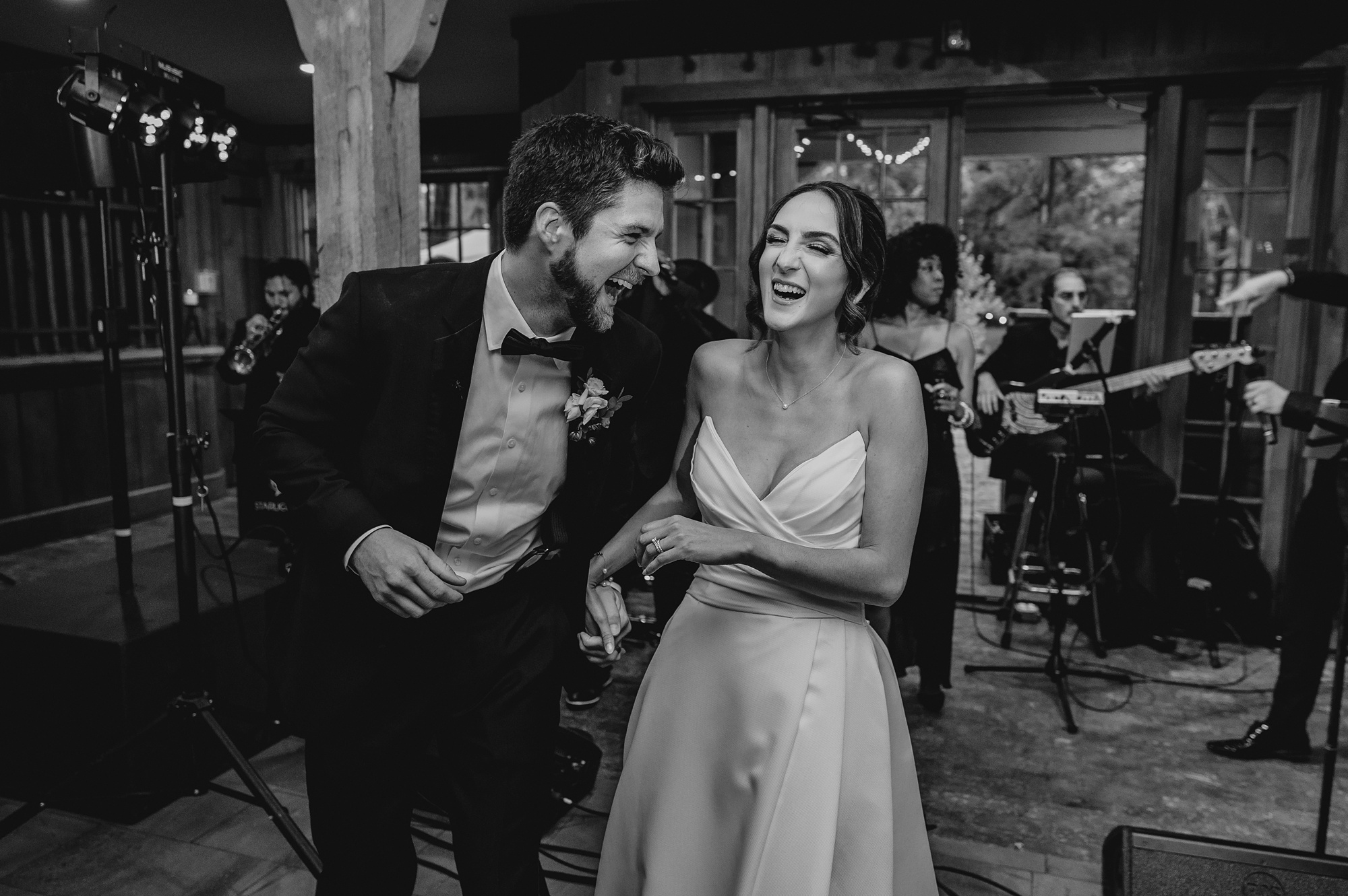 newlyweds laugh on dance floor during wedding reception 