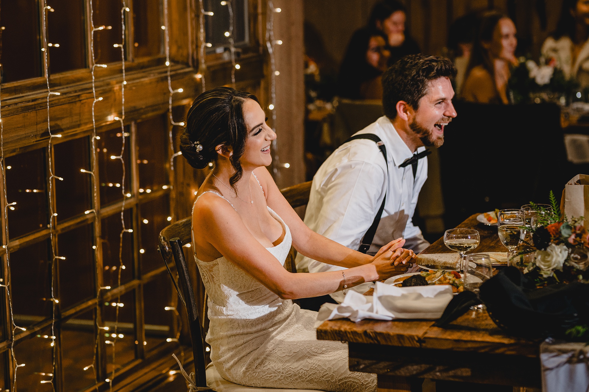 groom leans into bride laughing during speeches at Waterloo Village