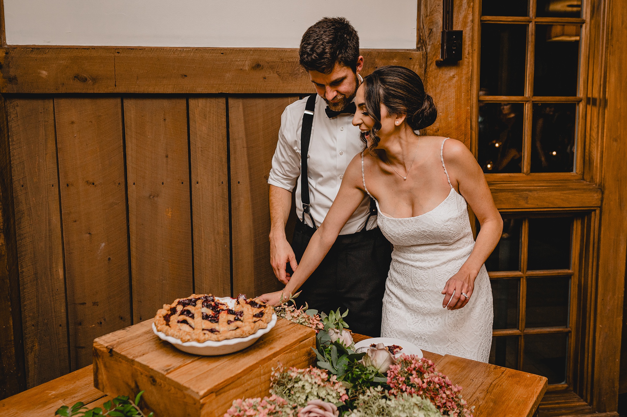 bride and groom cut pie during wedding reception 