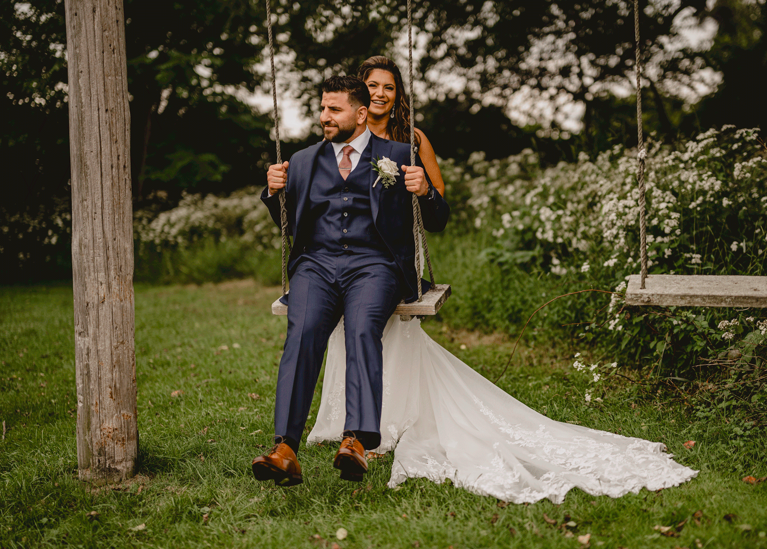 bride pushes groom on wooden swing at Skyview Golf Club