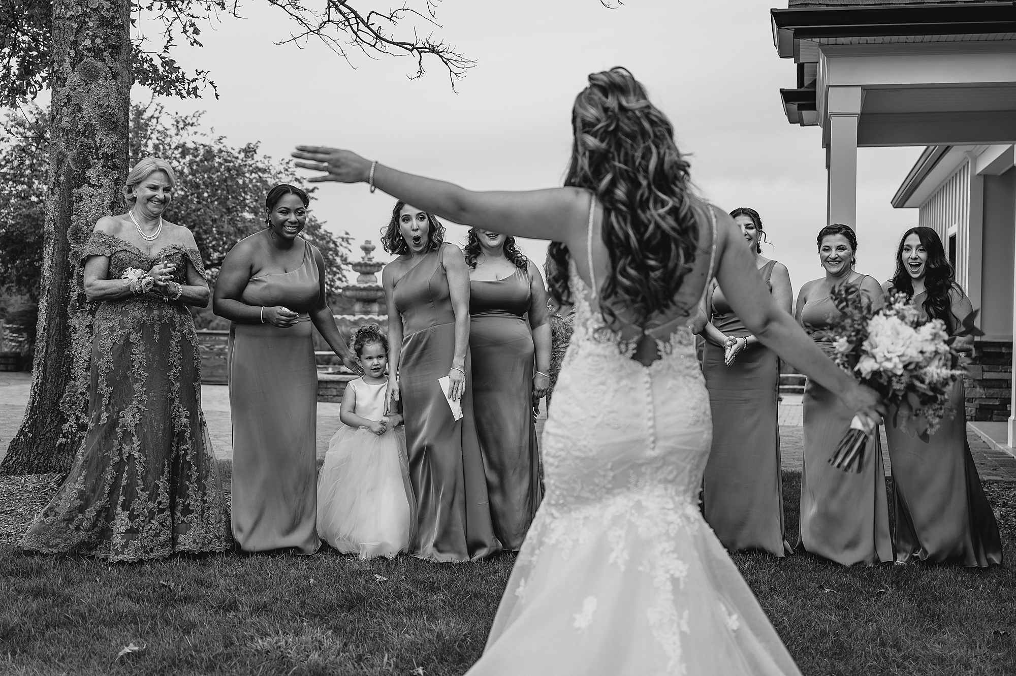 bride shows off wedding dress during first look with bridesmaids at Skyview Golf Club