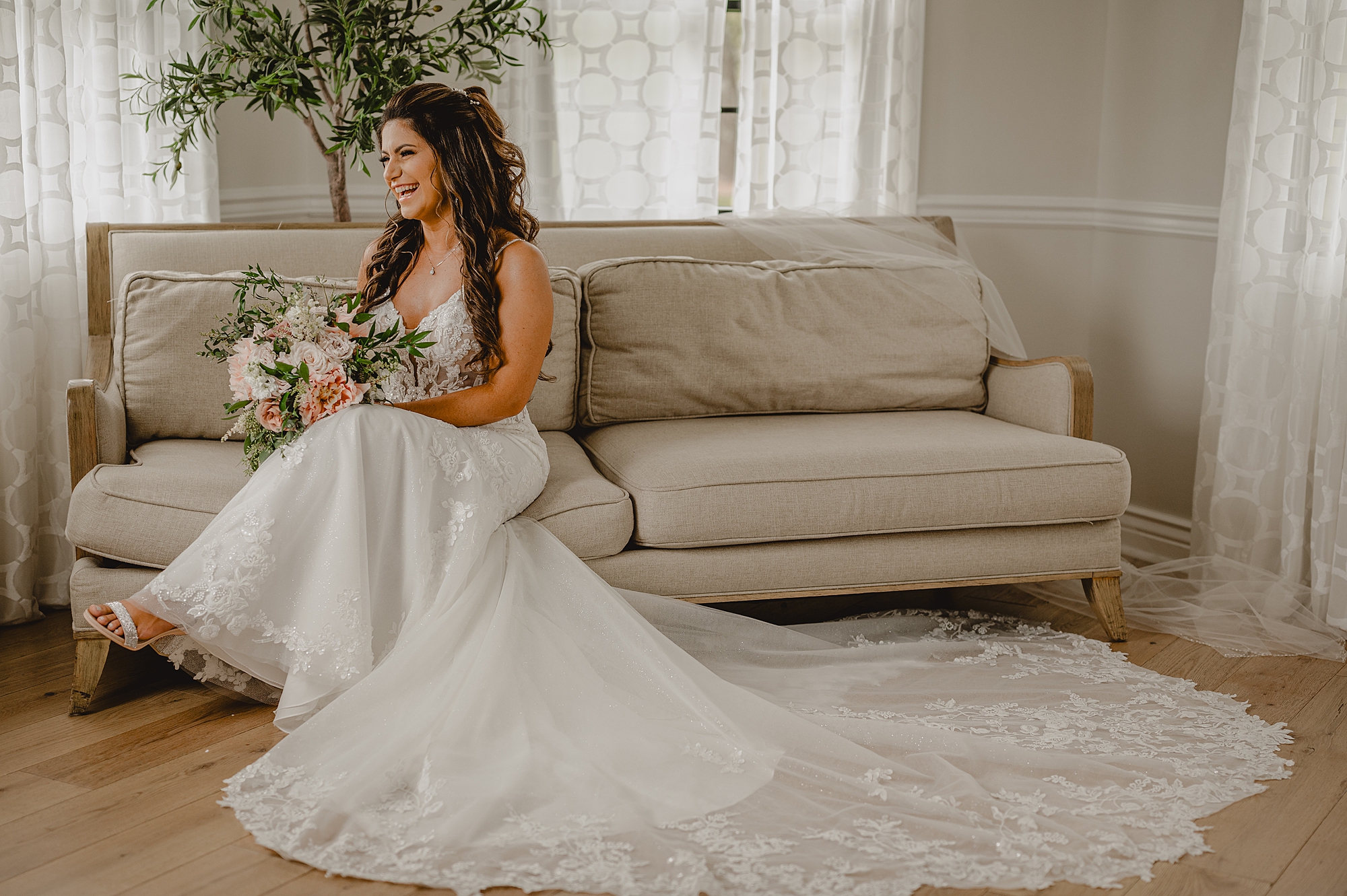 bride sits on tan sofa in bridal suite at Skyview Golf Club