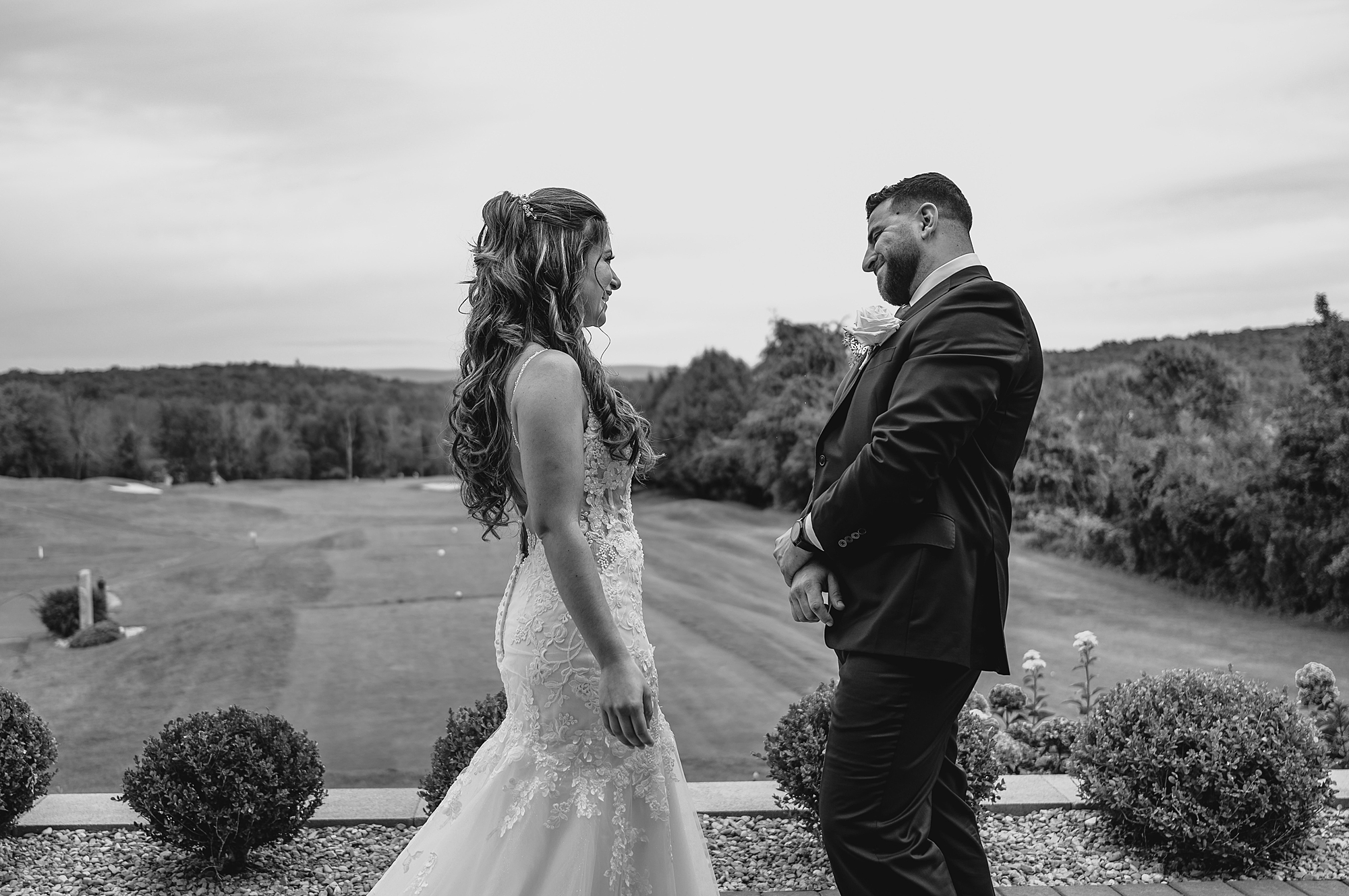 groom grins leaning back looking at bride at golf club