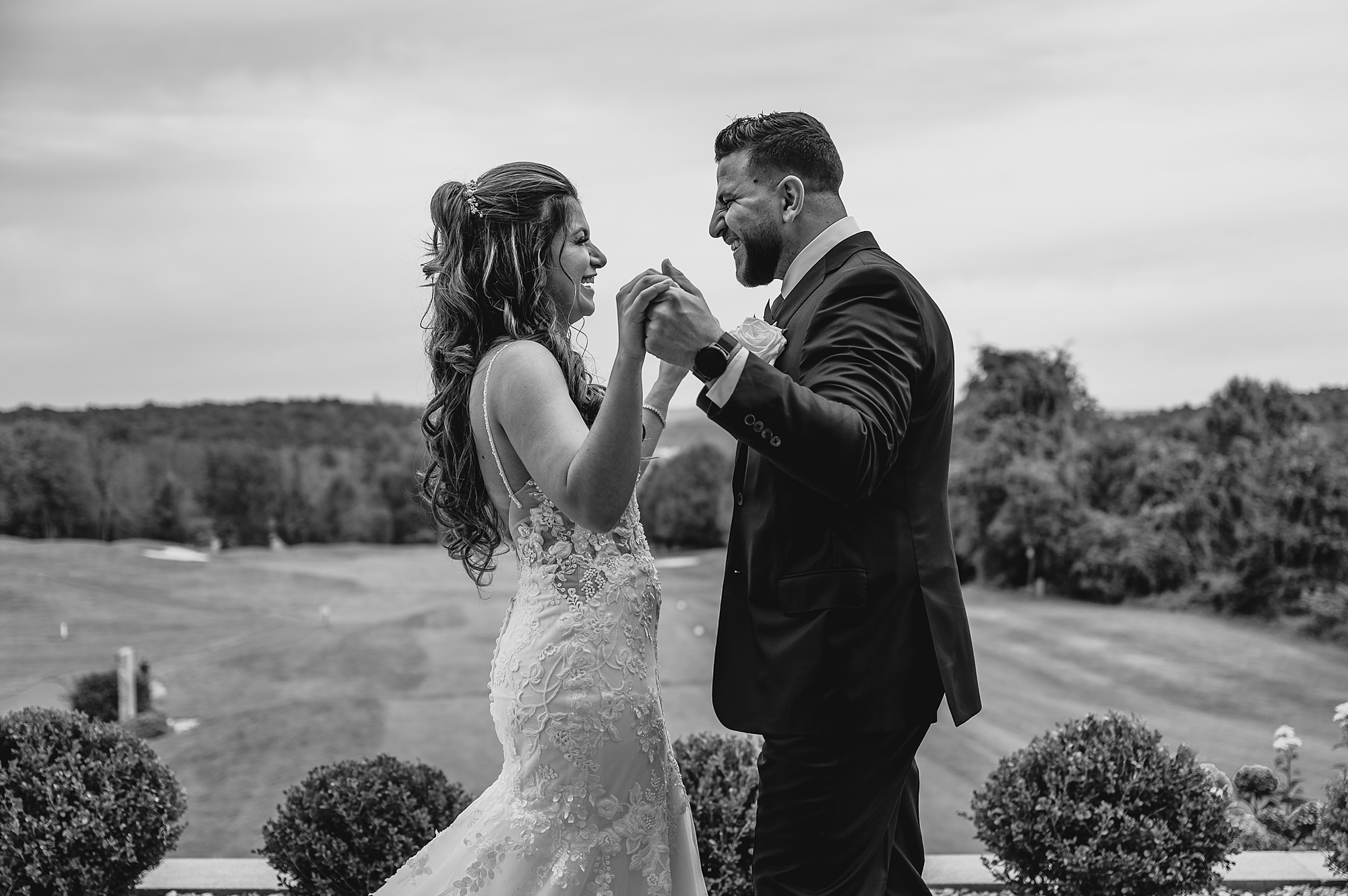 bride and groom hold hands smiling on patio in New Jersey