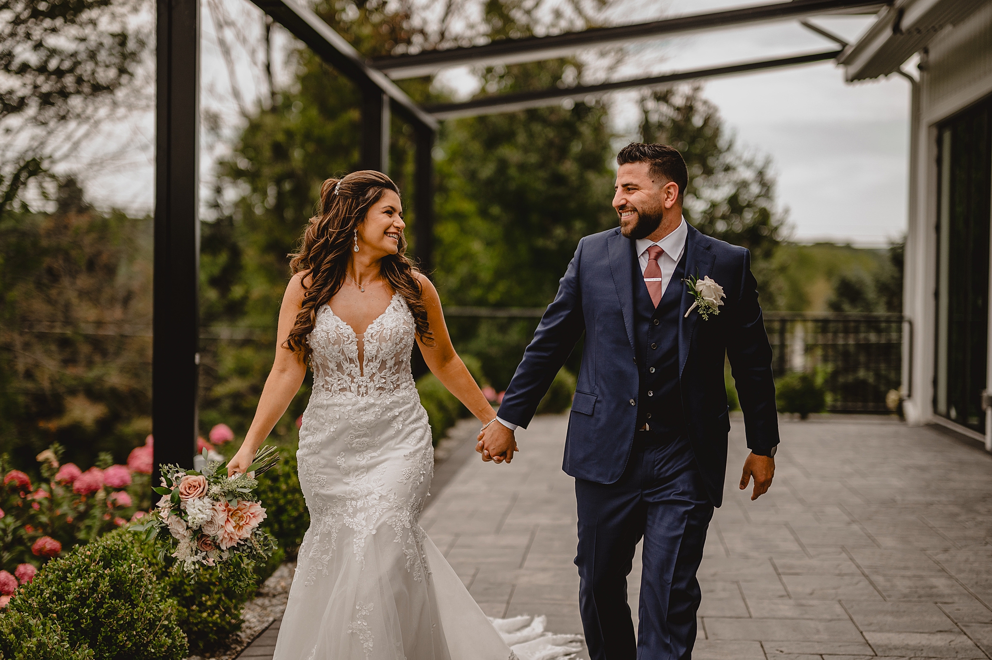 bride and groom hold hands walking under outdoor arbor at Skyview Golf Club