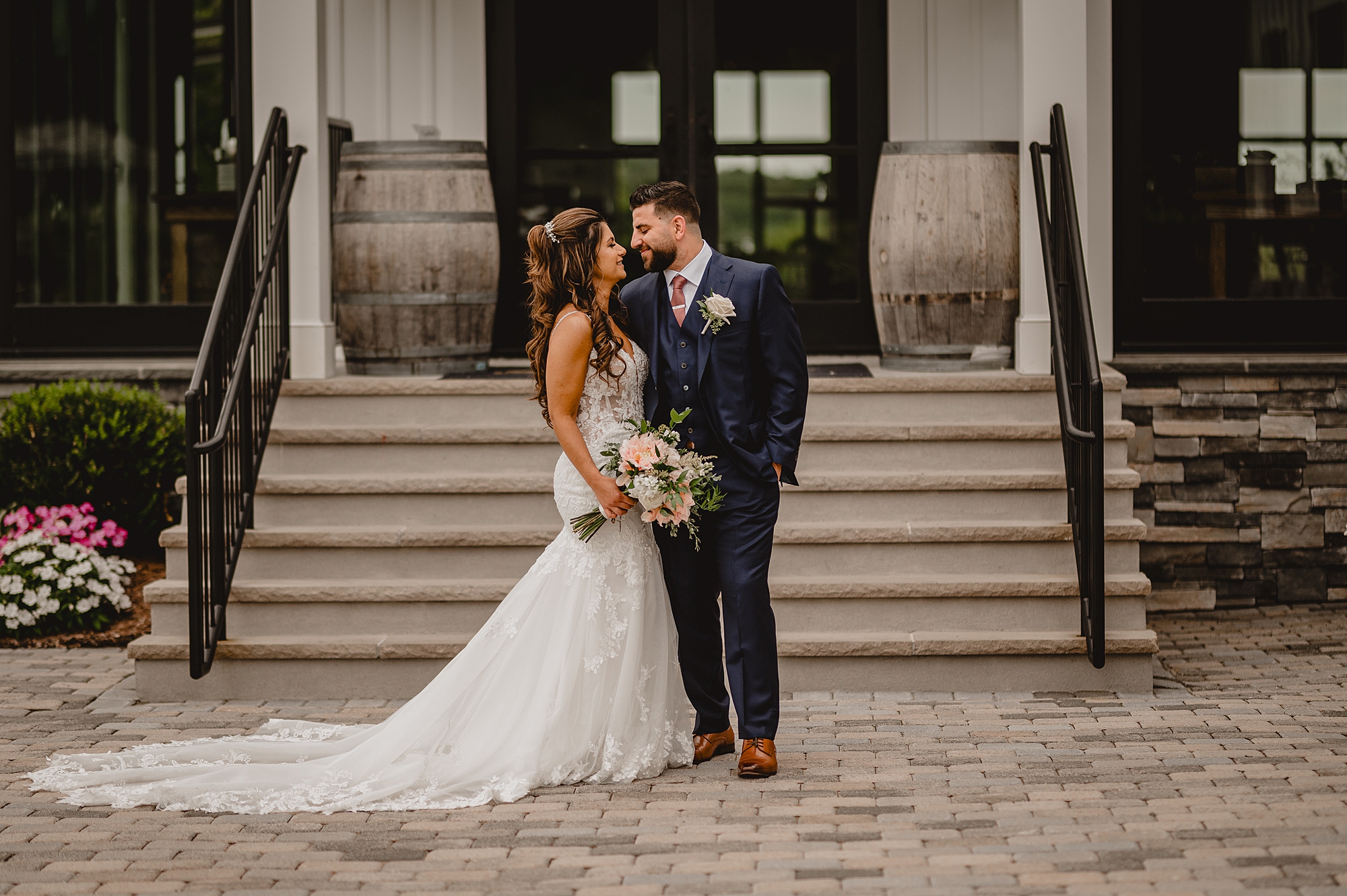 bride and groom hug leaning into teach other in front of staircase