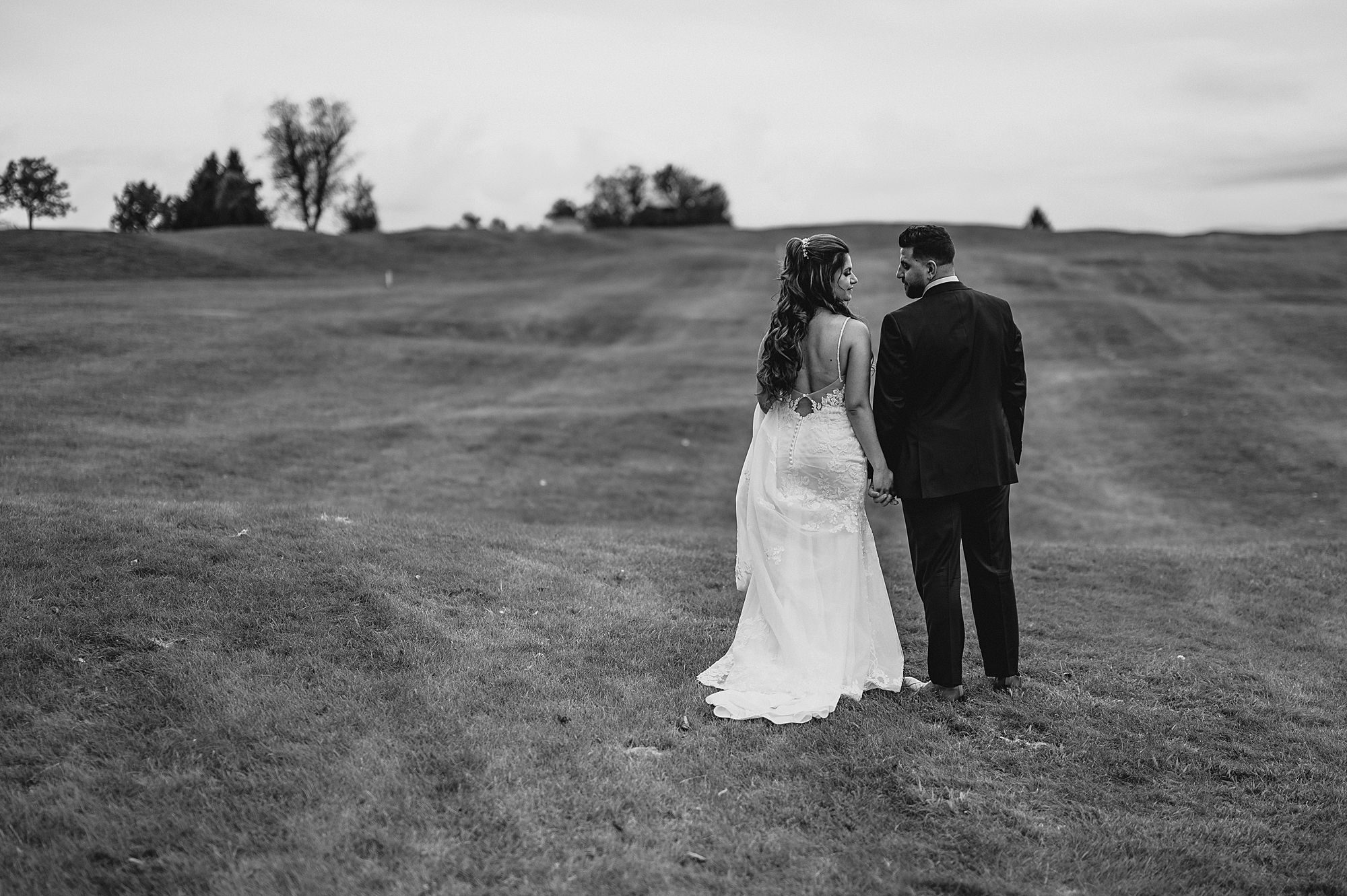 newlyweds walk together up hill at Skyview Golf Club