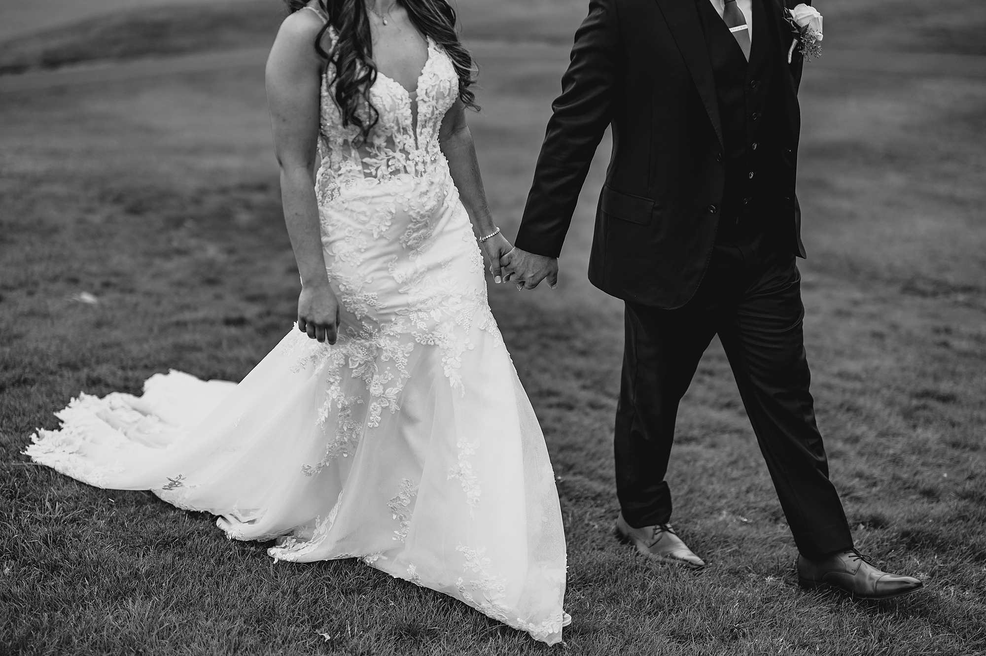 black and white photo of bride and groom holding hands