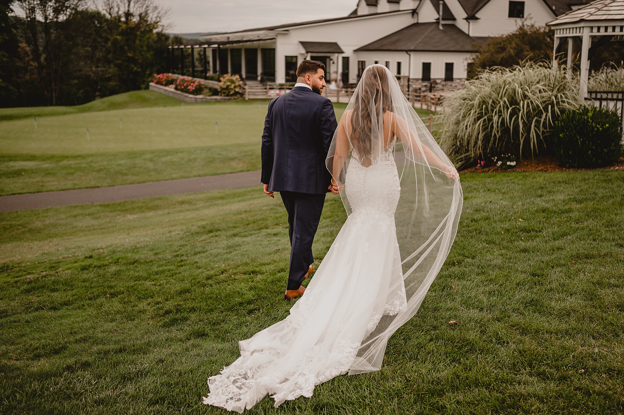 newlyweds walk towards venue at Skyview Golf Club