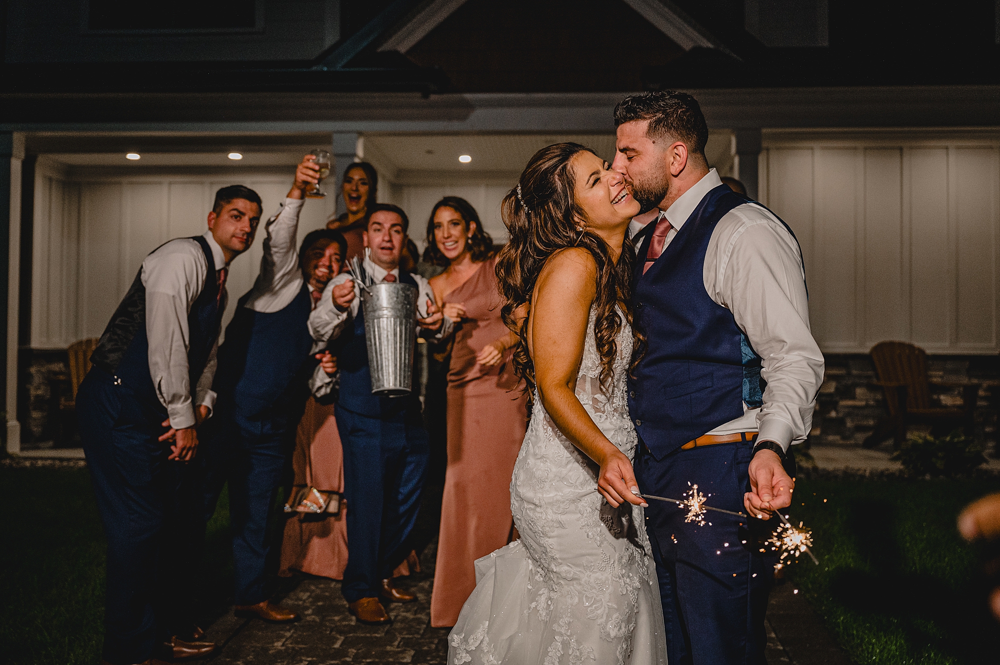 bride and groom hug while groom holds sparklers