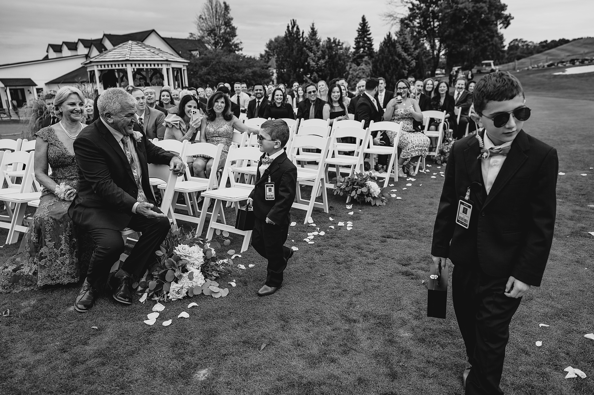 ring bearers walk down aisle for ceremony on lawn at Skyview Golf Club
