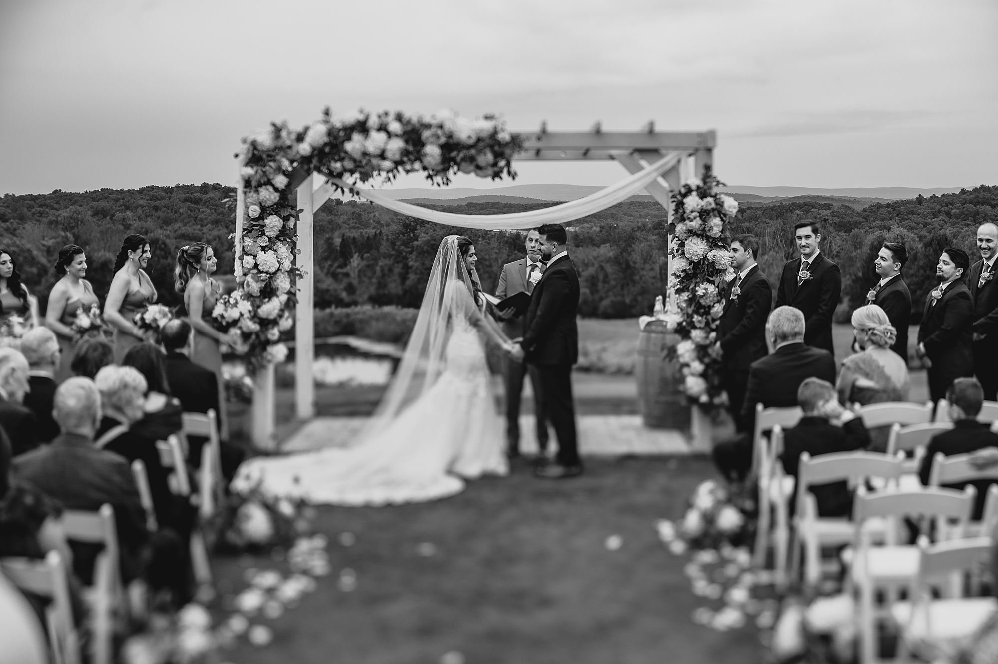 bride and groom hold hands during ceremony on lawn at Skyview Golf Club
