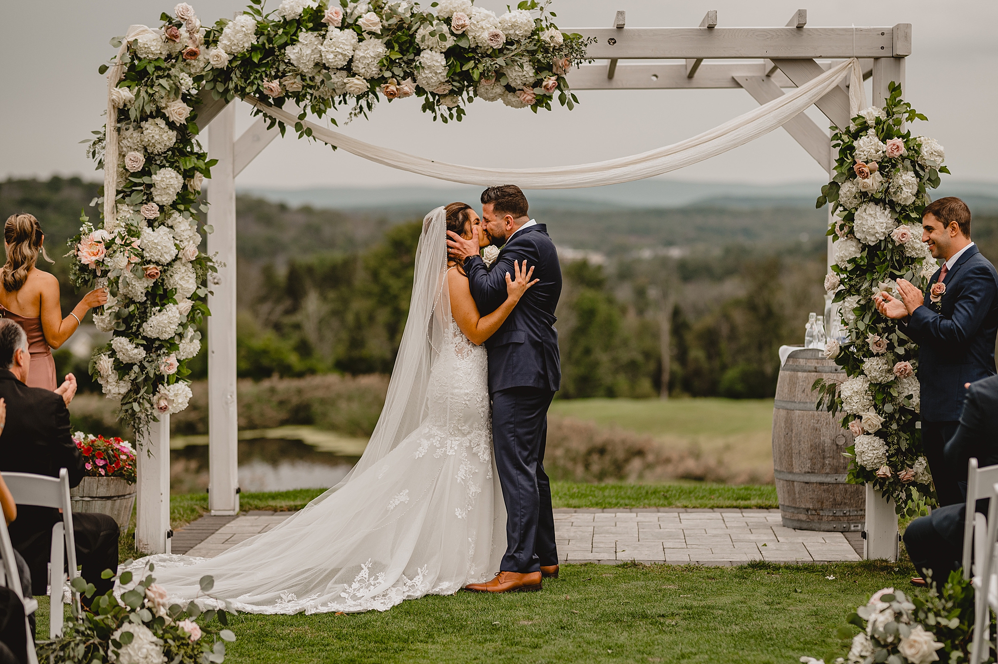 newlyweds kiss after ceremony on lawn at Skyview Golf Club