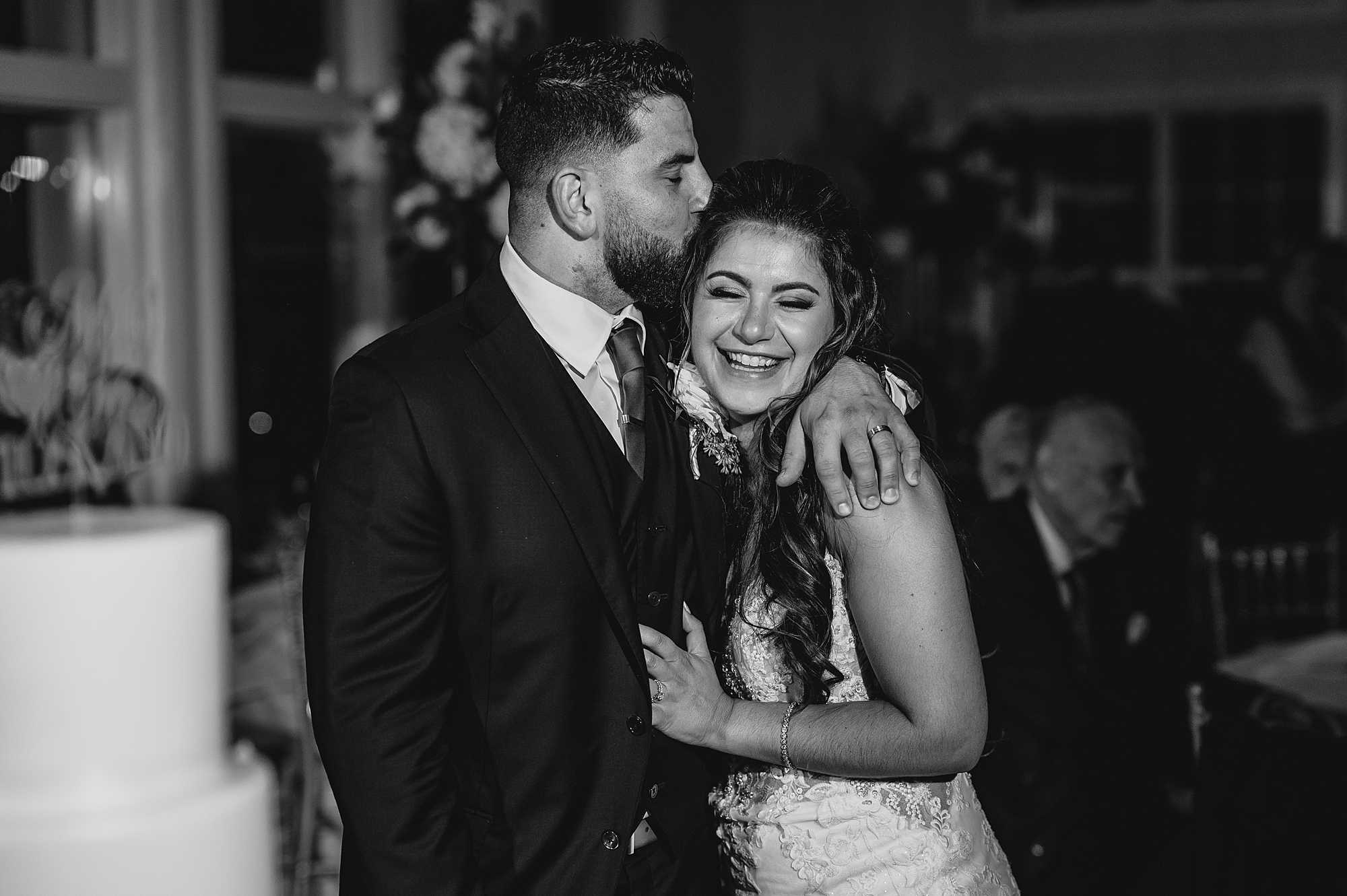 groom hugs bride to him making her laugh and kissing her forehead