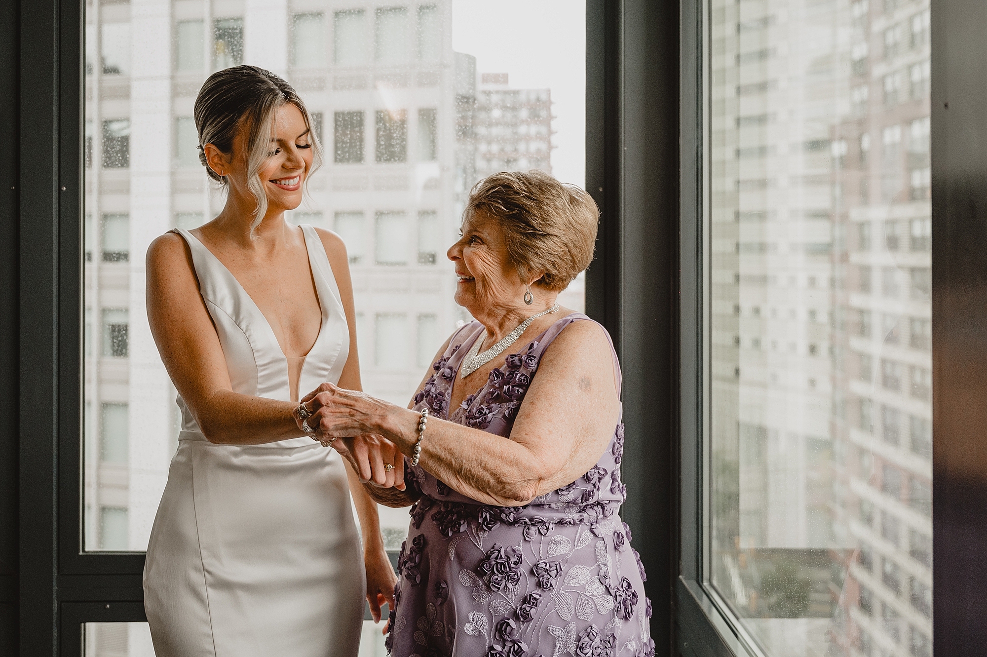 mother helps bride with bracelet on wedding day