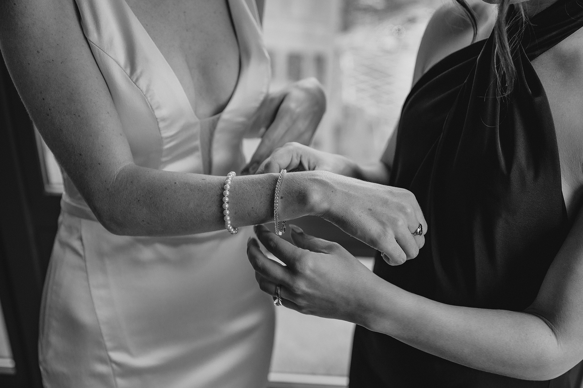 bride and bridesmaid adjust bracelet on wrist in hotel in Jersey City