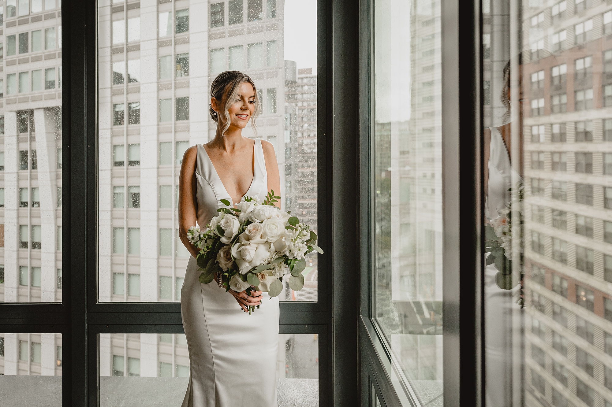 bride holds bouquet of white flowers looking at Jersey City
