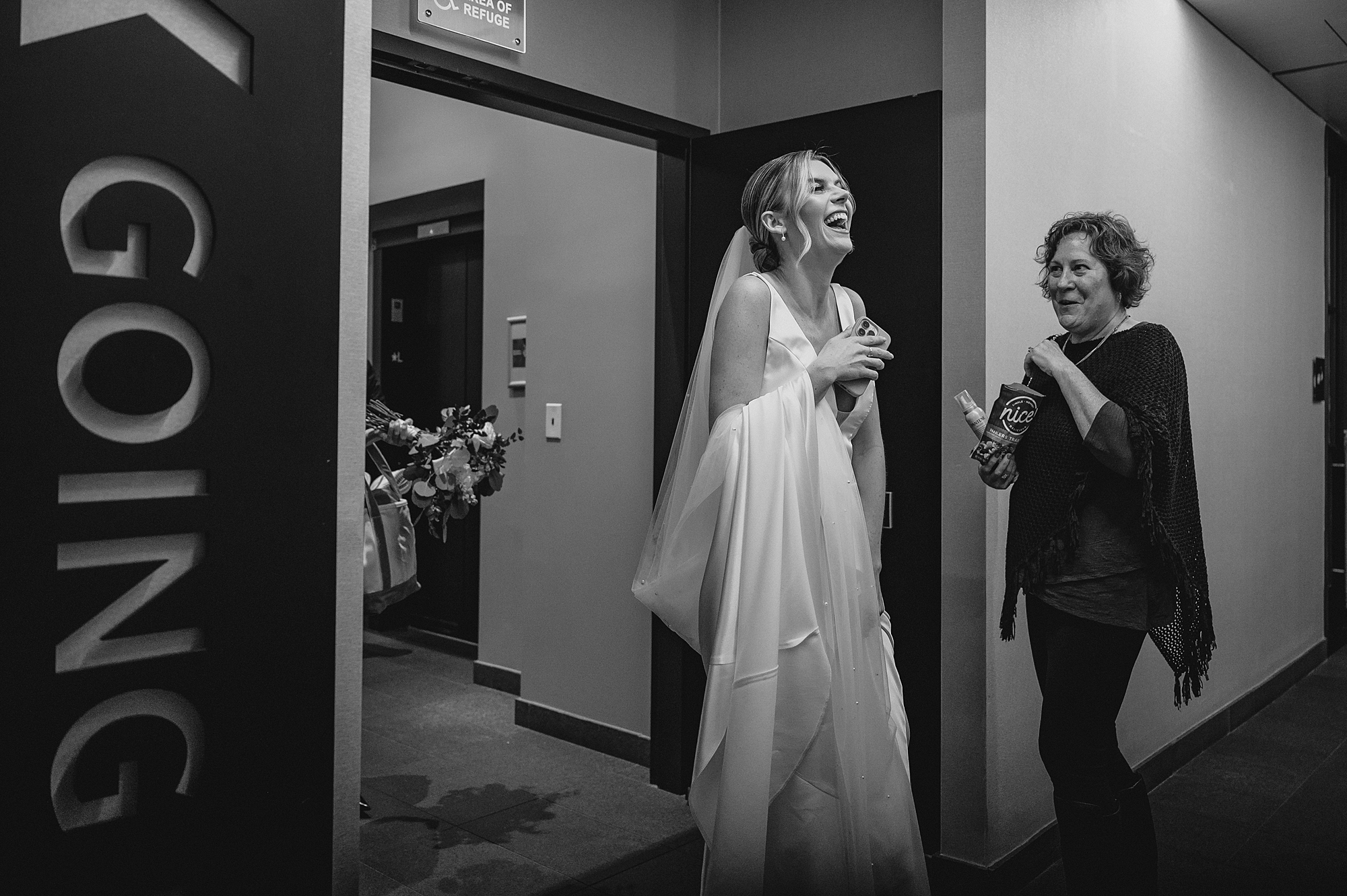 bride laughs with woman in hallway of Jersey City hotel