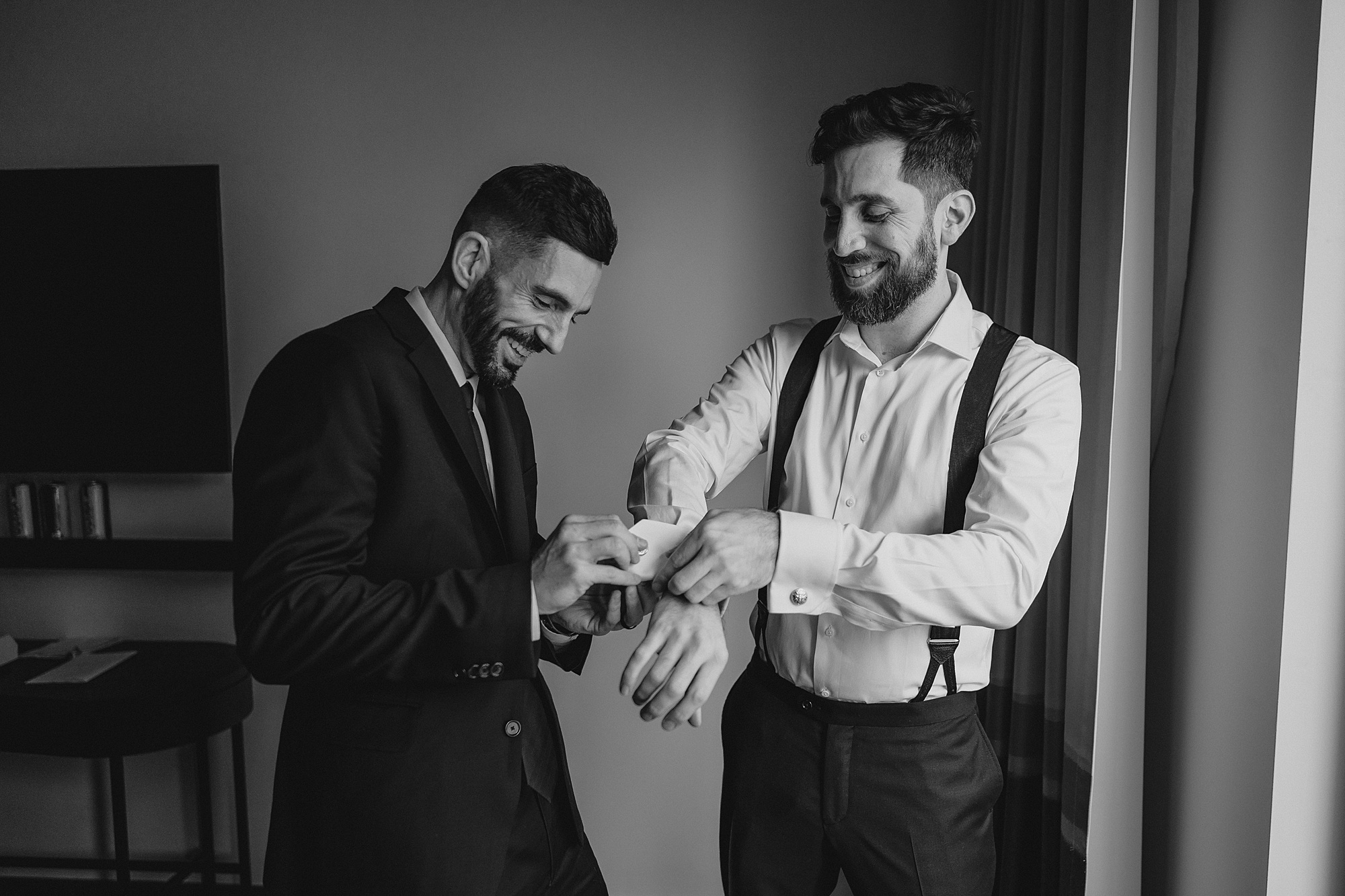 man helps groom with cufflinks during prep for Jersey City wedding day