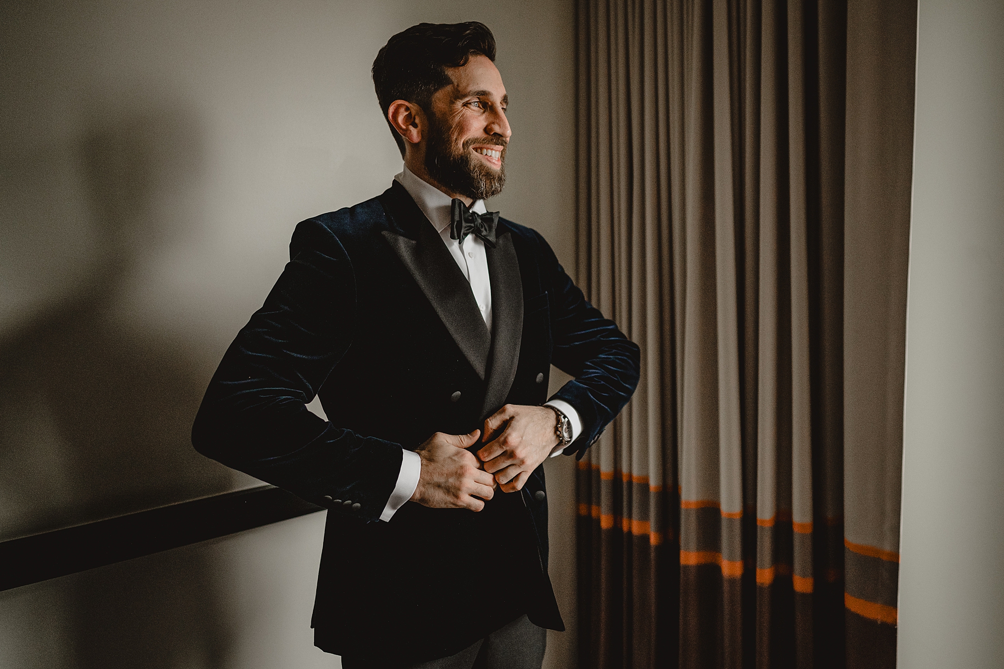man adjusts velvet suit jacket before Maritime Parc wedding day