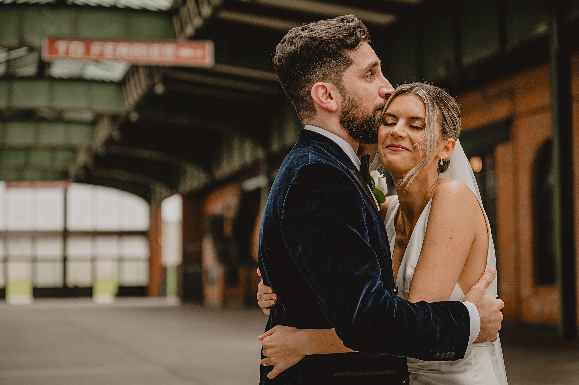 groom kisses bride while hugging her to his chest at Maritime Parc