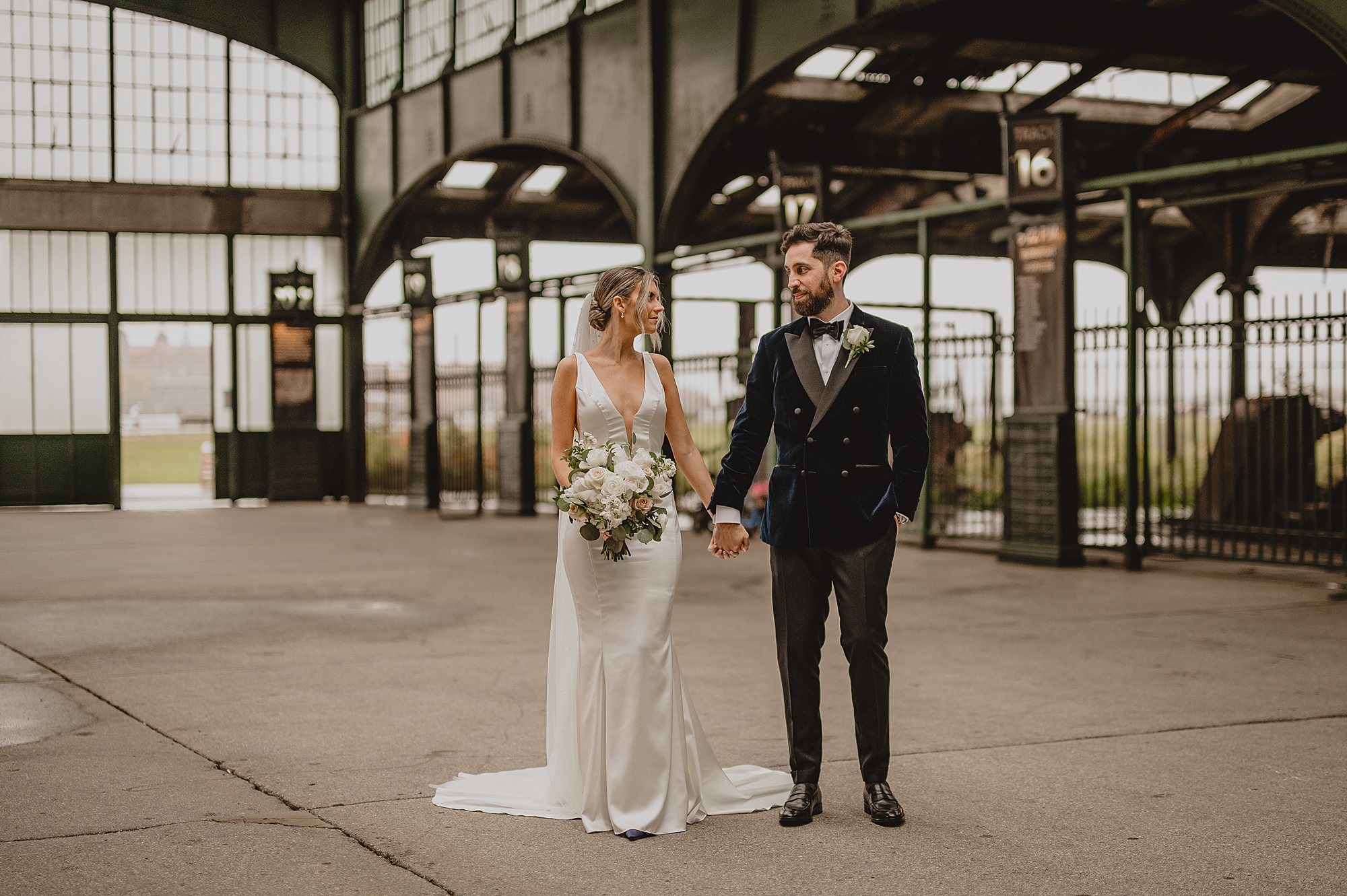 bride and groom hold hands walking inside Maritime Parc