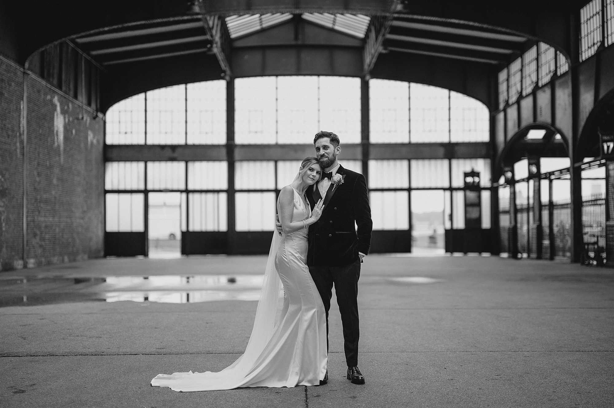 bride leans head on groom's chest posing inside Maritime Parc