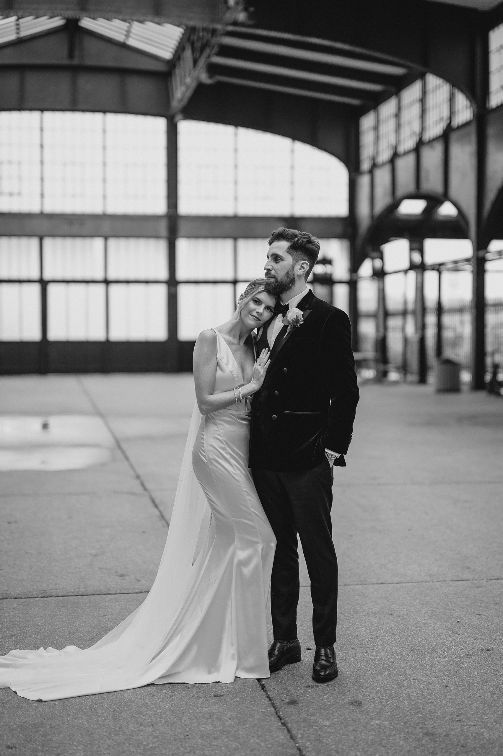 bride leans on groom's chest in black and white photo at Maritime Parc