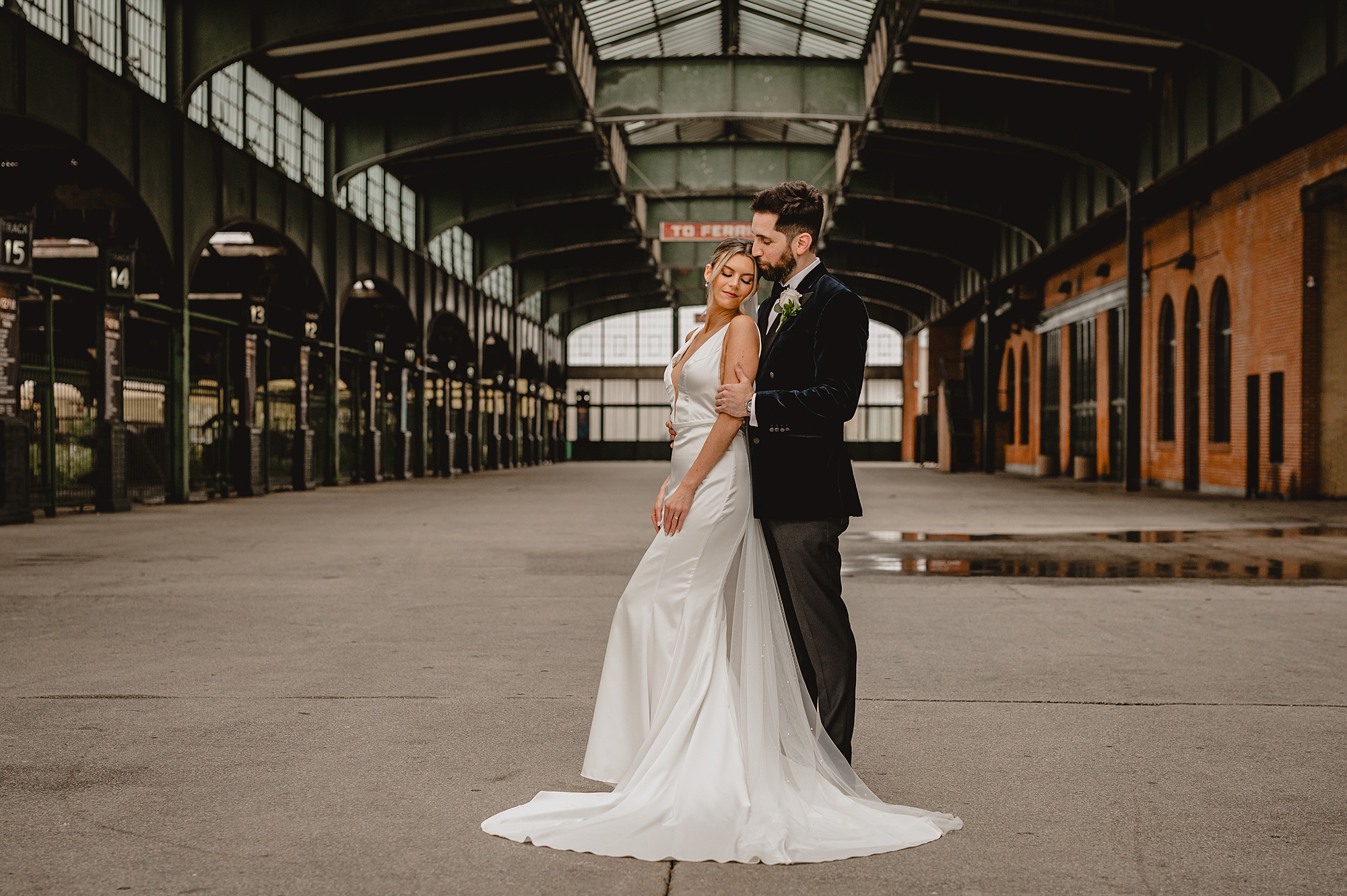 groom hugs bride from behind inside Maritime Parc