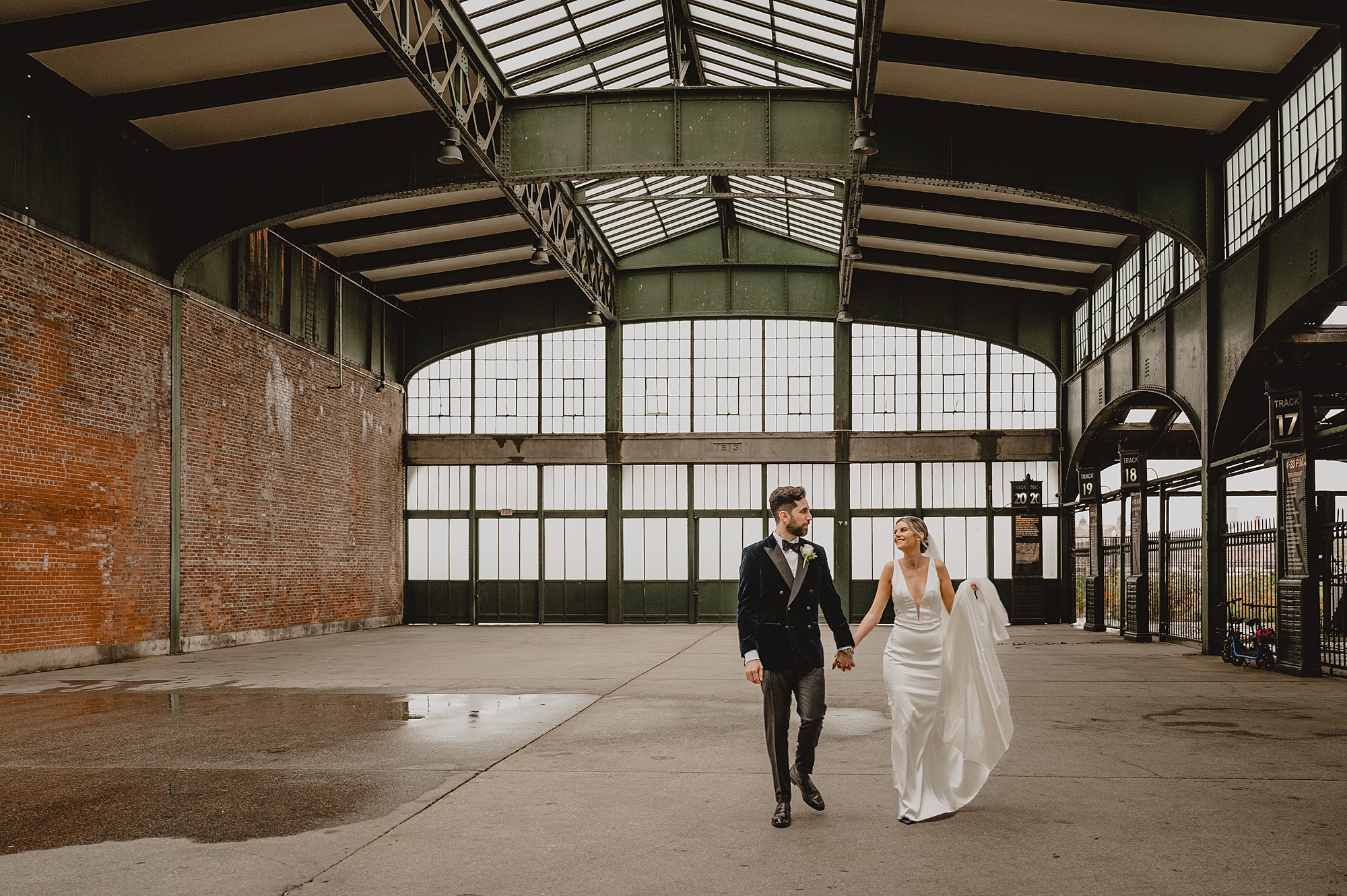 bride and groom hold hands walking through inside of Maritime Parc