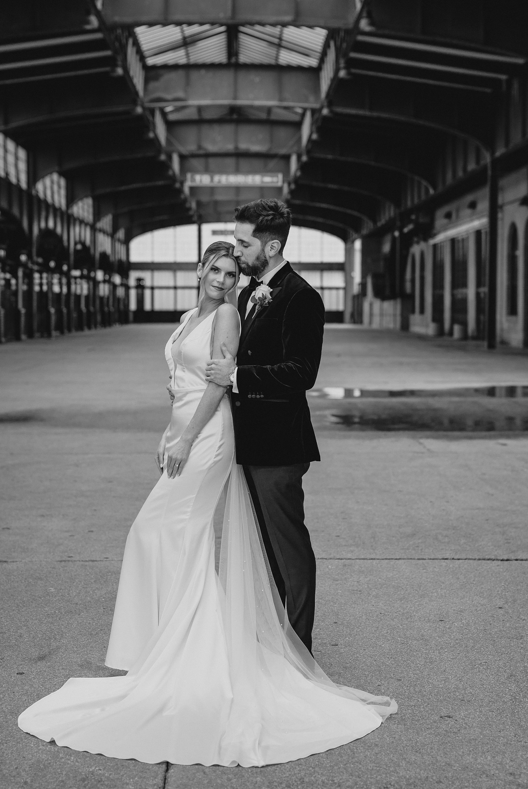 groom hugs bride from behind standing inside Maritime Parc
