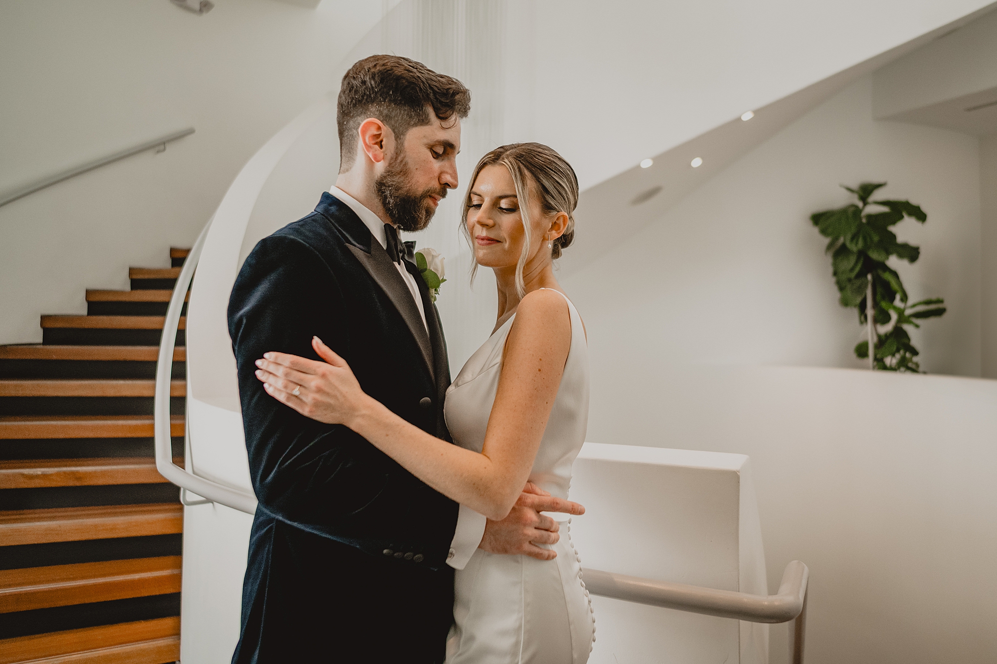 bride and groom hug by white spiral staircase at Maritime Parc