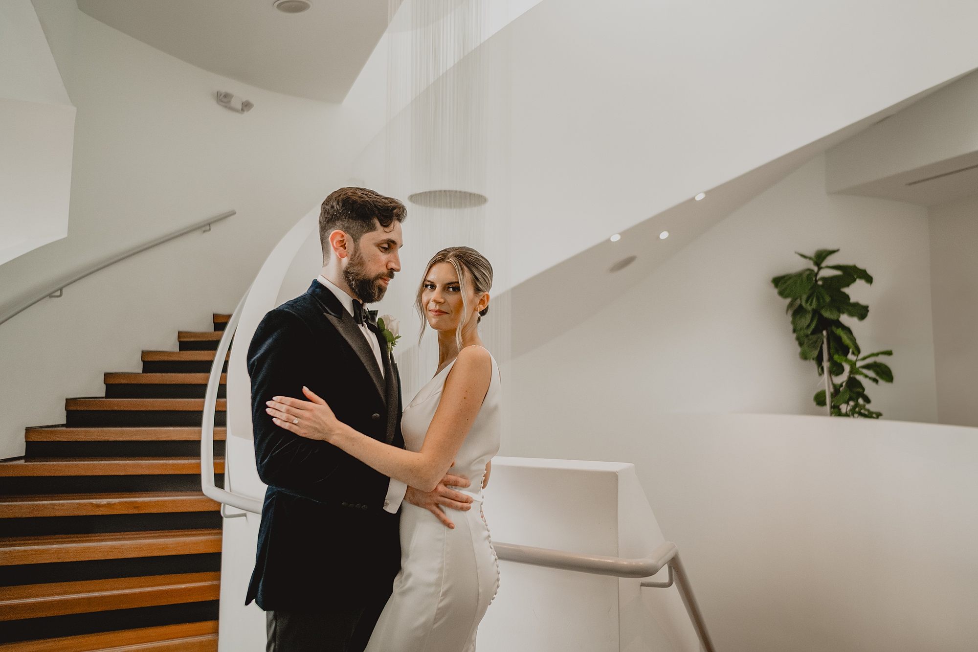 newlyweds hug inside staircase at Maritime Parc