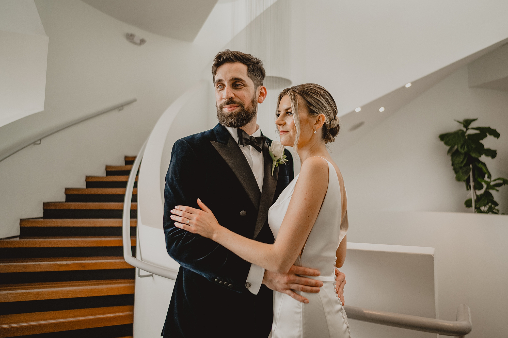 bride hugs groom in velvet suit inside Maritime Parc